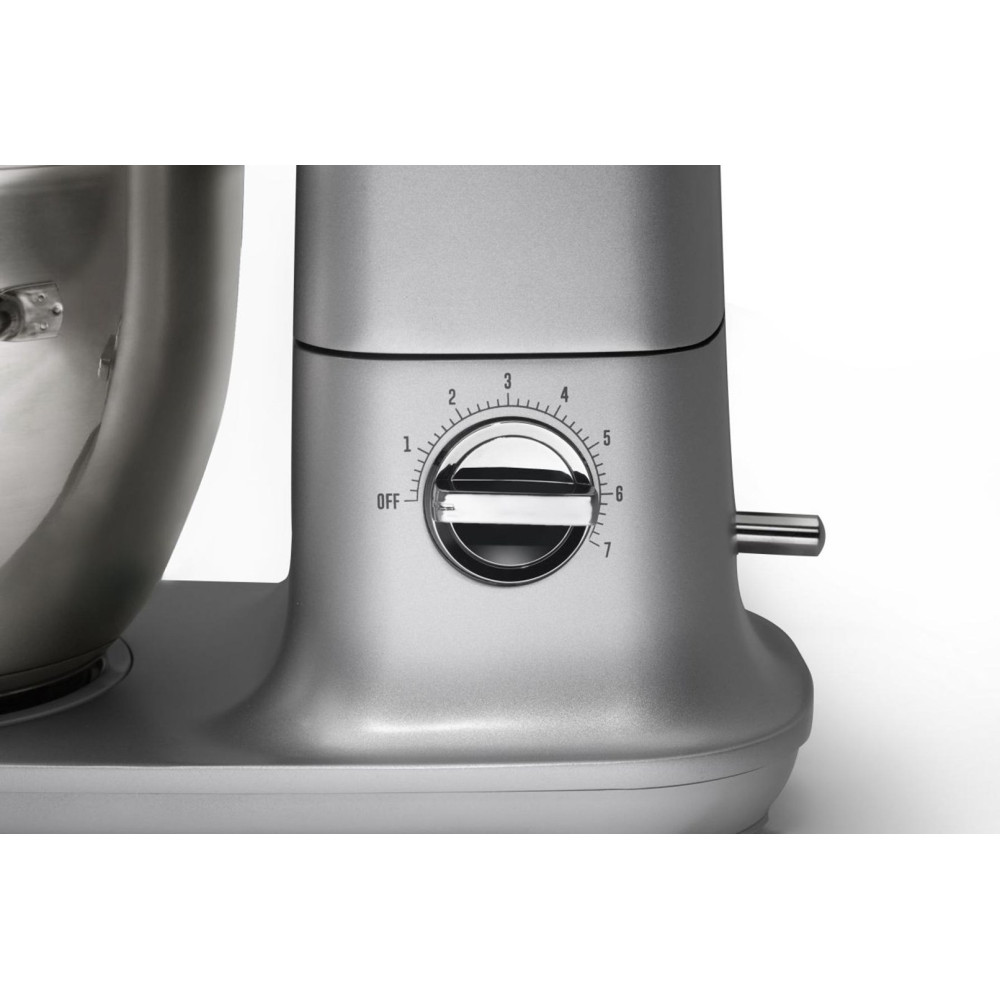 Zbliżenie srebrnego miksera stojącego. Pokrętło wskazuje ustawienia prędkości od wyłączenia do 7. Miska ze stali nierdzewnej po lewej stronie.