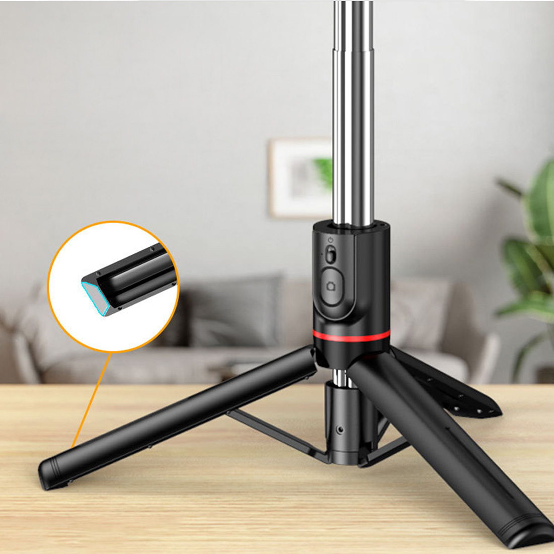 Telefon tutuculu siyah ve gümüş bir tripod. Yakın çekim tutucunun bir detayını gösteriyor. Arka plan bir oturma odası.