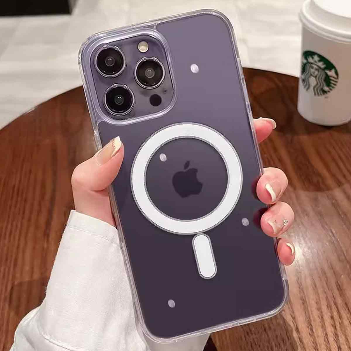 Eine Hand hält ein lila iPhone mit einer durchsichtigen Hülle und einem weißen Magnetring. Im Hintergrund ist ein Starbucks-Becher.