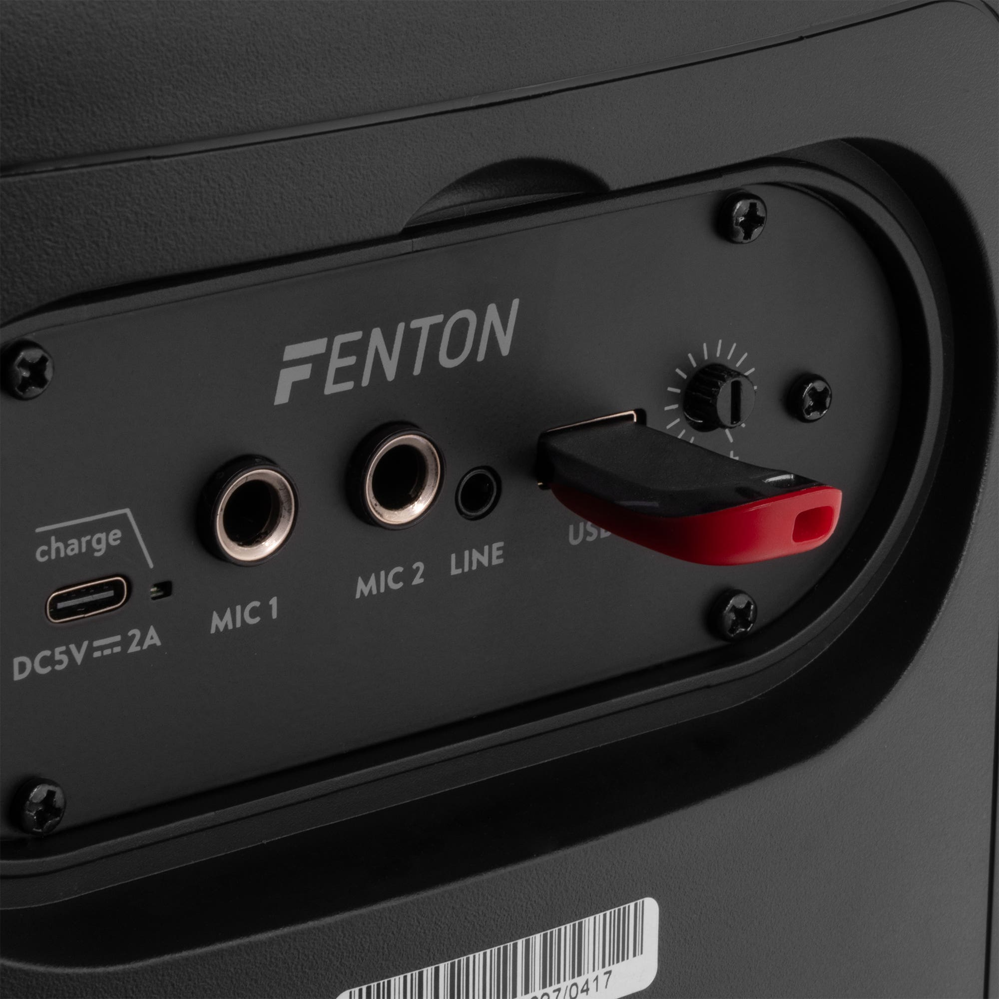 Primer plano de un panel de altavoz negro con entradas: MIC, LINE, USB. Una unidad USB está enchufada. La marca es FENTON.