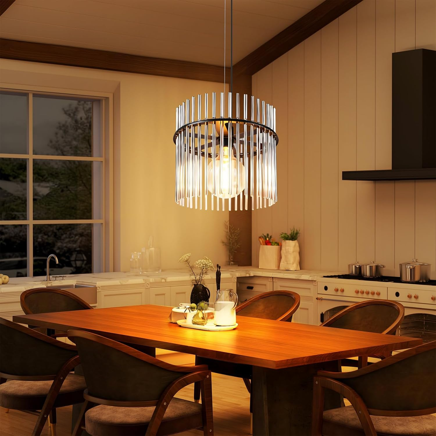 Una sala da pranzo con tavolo in legno, sedie e lampadario. Sullo sfondo si vede una cucina.