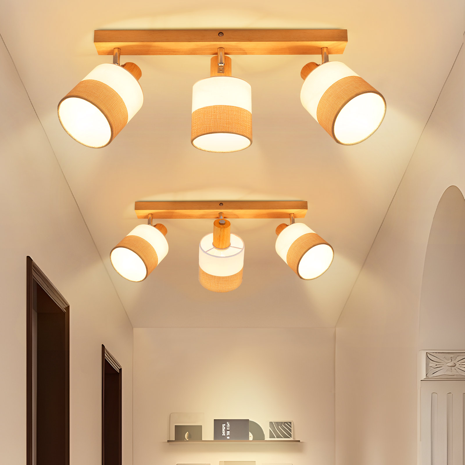 Due set di luci a soffitto. Ognuno ha tre faretti con paralumi bianchi e marroni. Le luci sono in un corridoio.