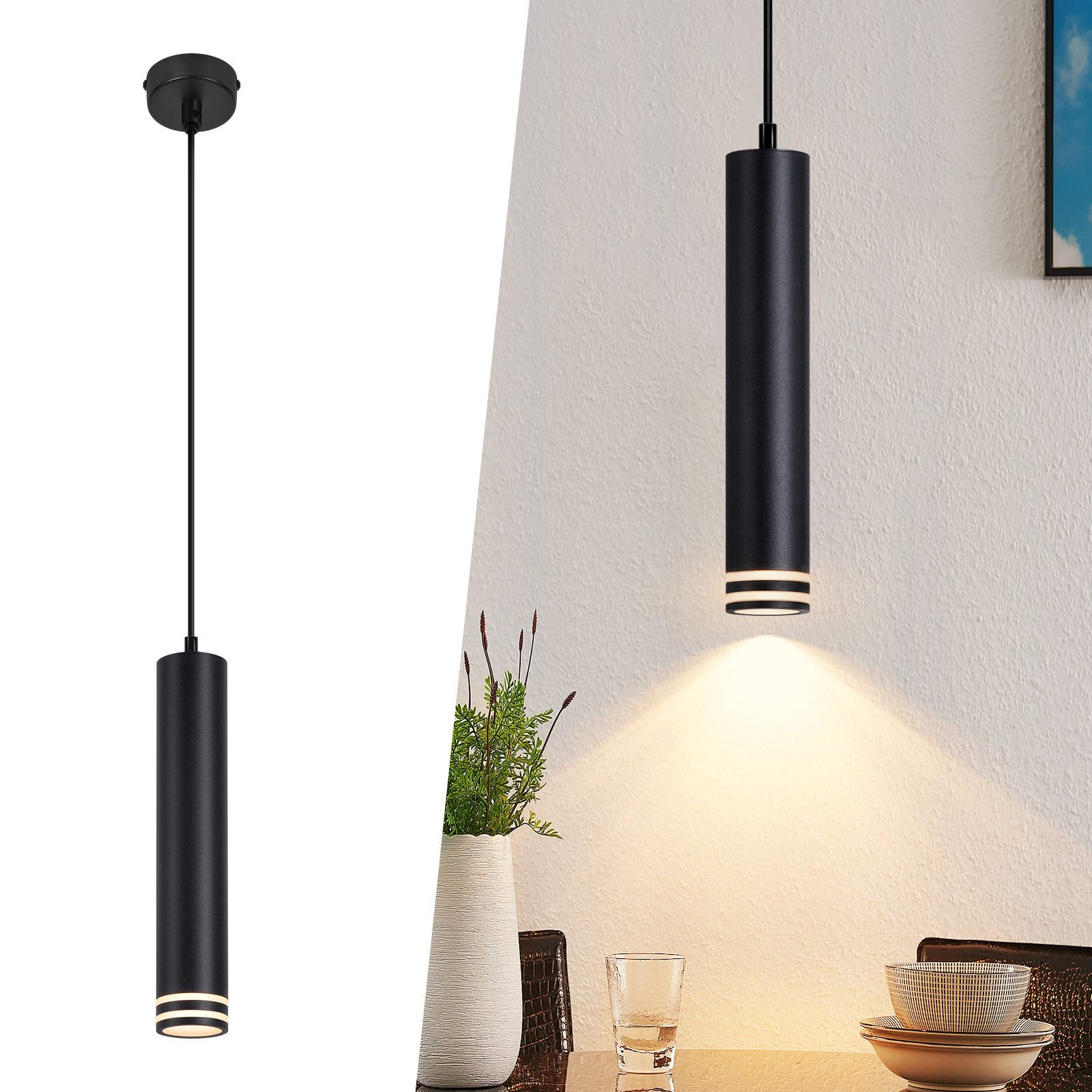Lampada a sospensione cilindrica nera con strisce bianche, appesa in una stanza. Sono visibili anche un vaso di piante e un tavolo.