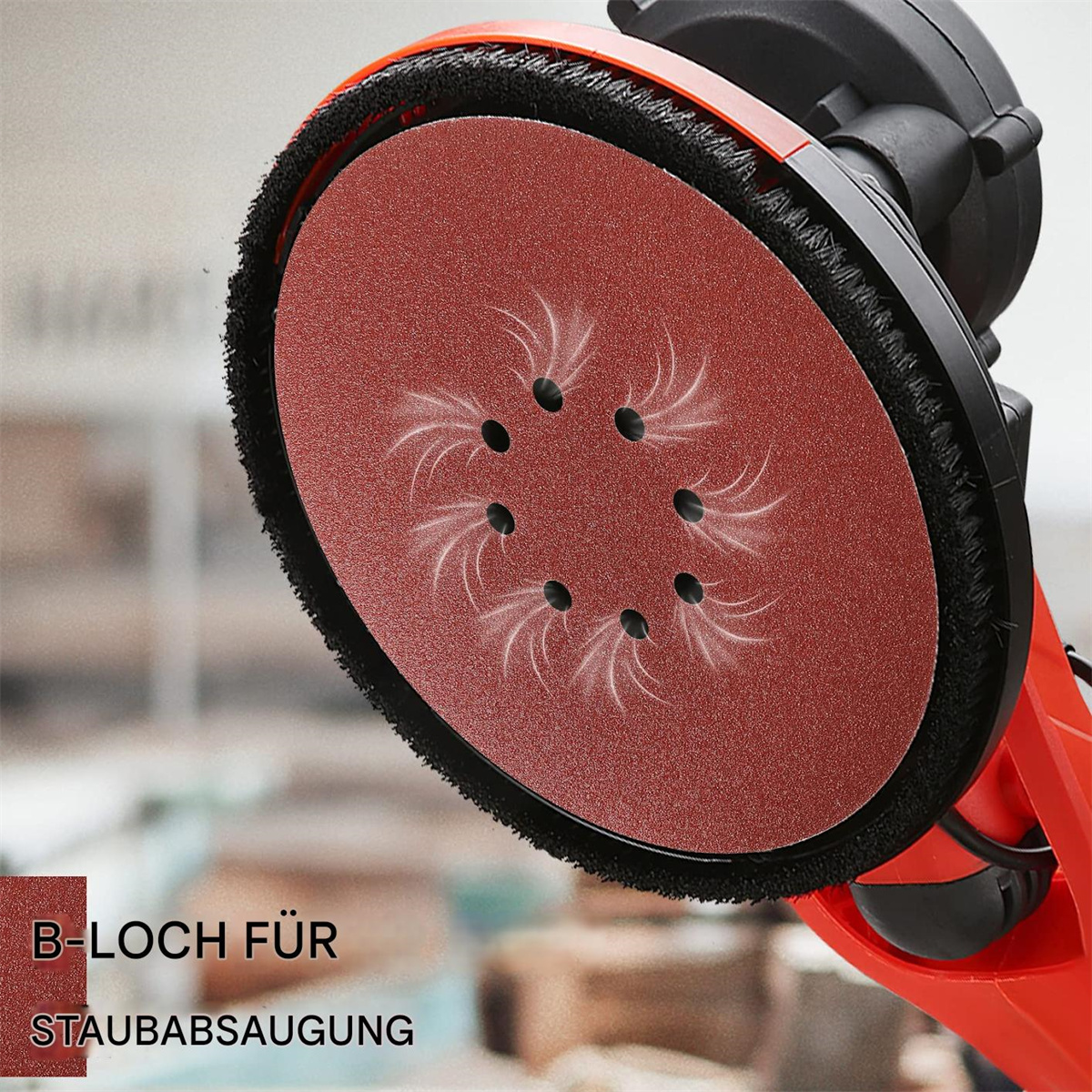 Eine rote Schleifmaschine mit rundem Pad. Sie hat eine schwarze Bürste und einen roten Griff. Text lautet 'B-LOCH FÜR STAUBSAUGUNG'.