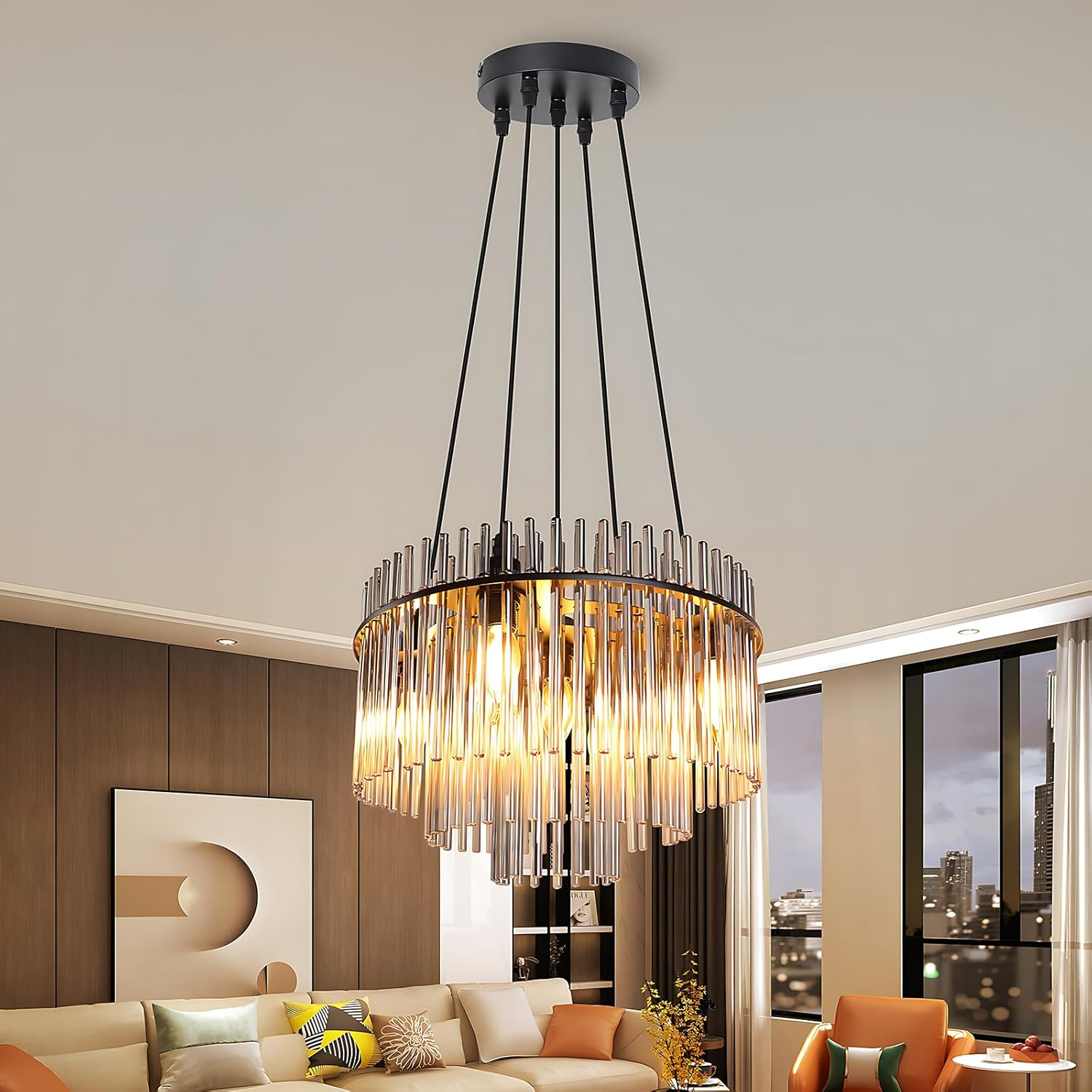 Un lampadario moderno con aste di vetro è appeso in un soggiorno. Visibili un divano, un'opera d'arte e la vista della città.
