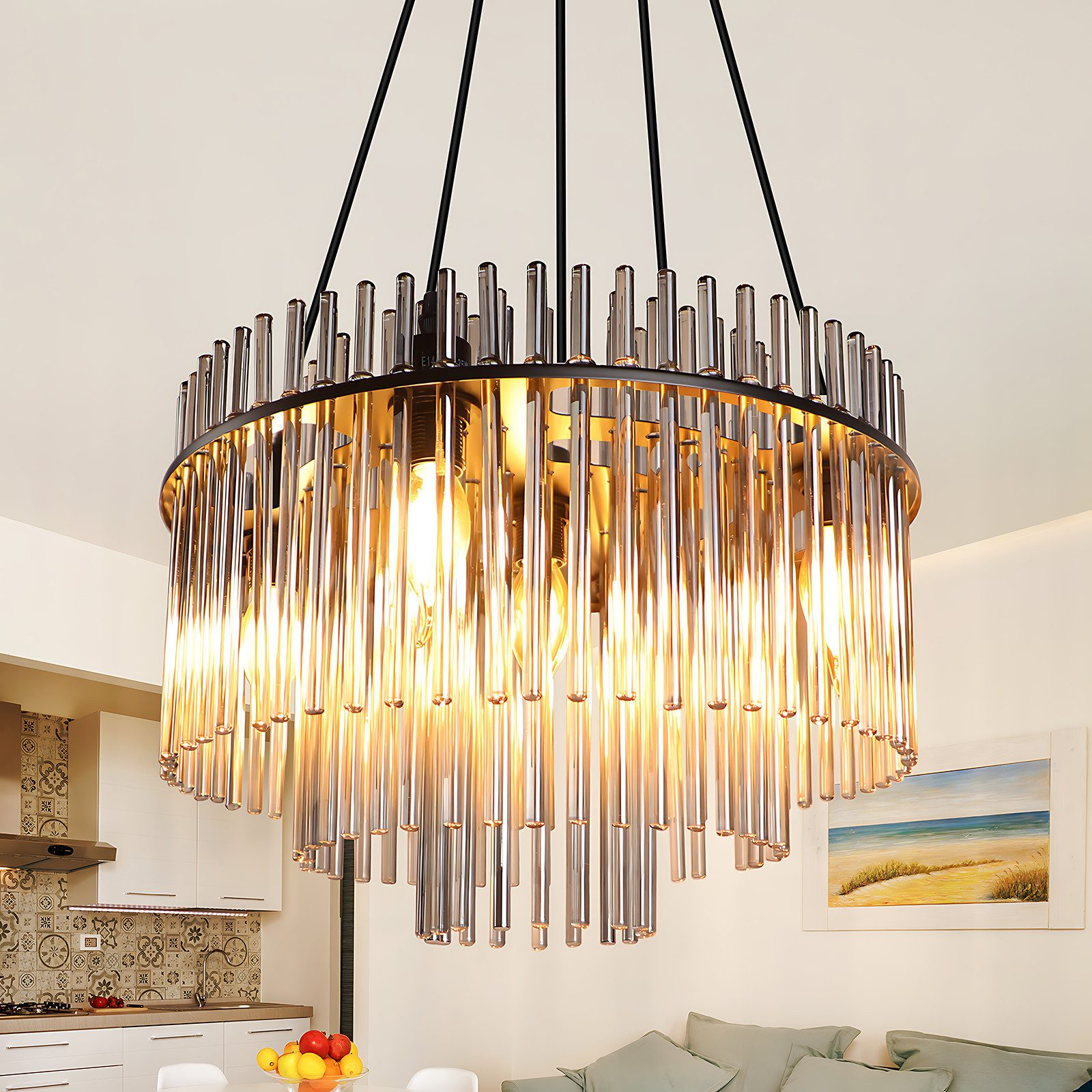 Un lampadario rotondo con aste di vetro è appeso in una stanza. Cucina e dipinto sono visibili sullo sfondo.