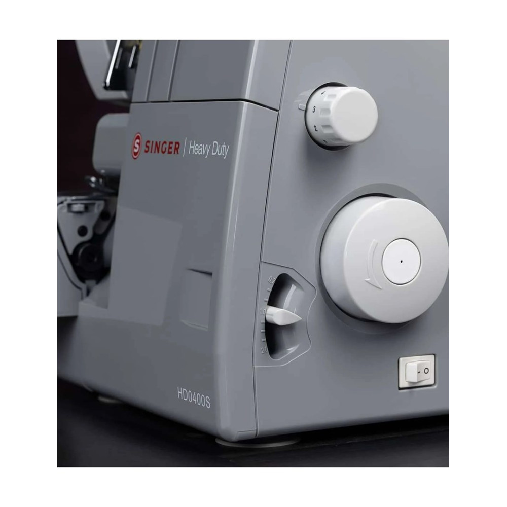 Szczegół szarej maszyny do szycia Singer Heavy Duty. Ma białe pokrętła i przełącznik, widoczny jest model HD0400S.