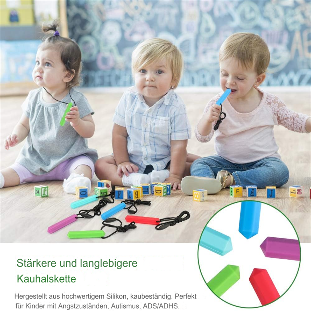 Drei Babys mit Kauschmuck sitzen mit Blöcken. Verschiedenfarbige Kauspielzeug-Sticks werden gezeigt. Im Hintergrund ist eine Tafel.