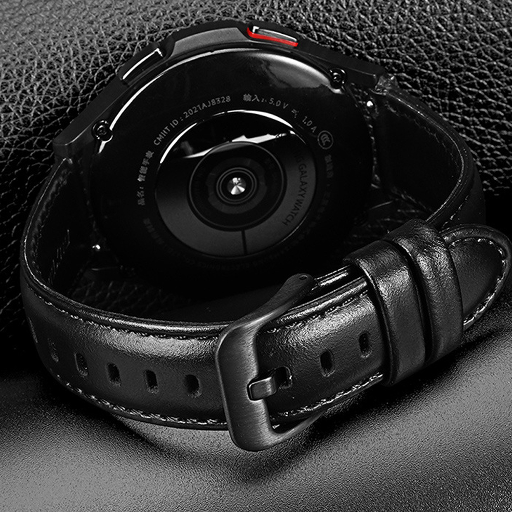 Eine schwarze Smartwatch mit Lederarmband liegt auf einer strukturierten Oberfläche. Die Uhr ist abgewinkelt, Details des Bands.