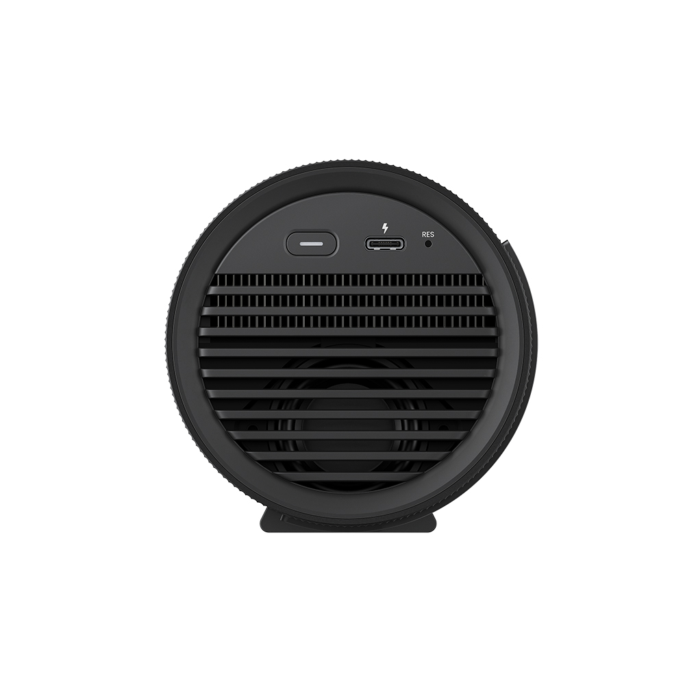 Ein schwarzes, zylindrisches Gerät mit Frontgrill, Anschlüssen und einem Netzschalter. Das Gerät befindet sich auf weißem Hintergrund.