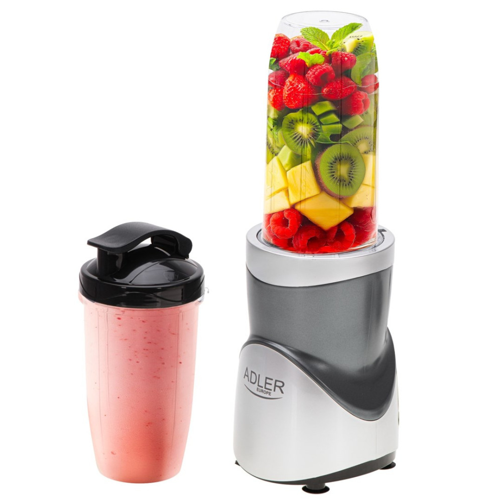Ein Mixer mit Früchten und ein Smoothie-Shaker daneben. Himbeere, Kiwi und Ananas sind im Mixer sichtbar.