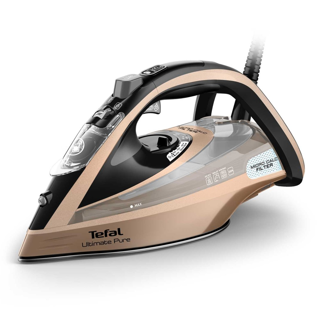 Żelazko Tefal Ultimate Pure. Jest złoto-czarne, ze zbiornikiem na wodę i etykietą Micro Calc Filter. Podstawa znajduje się na białej powierzchni.