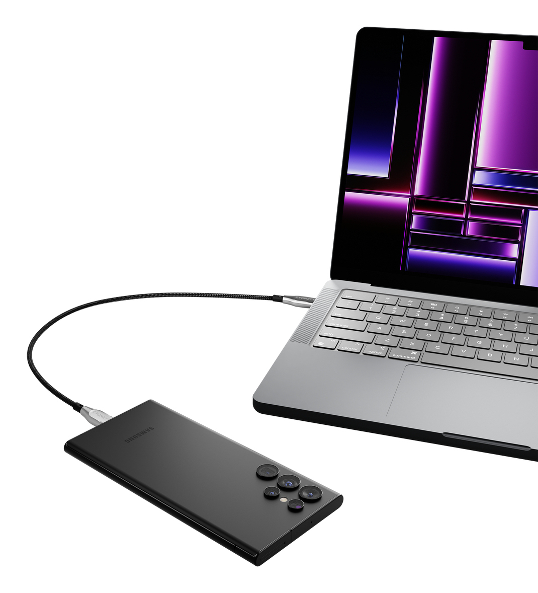 Un laptop è collegato a un telefono nero tramite un cavo. Lo schermo del laptop mostra immagini viola e bianche.