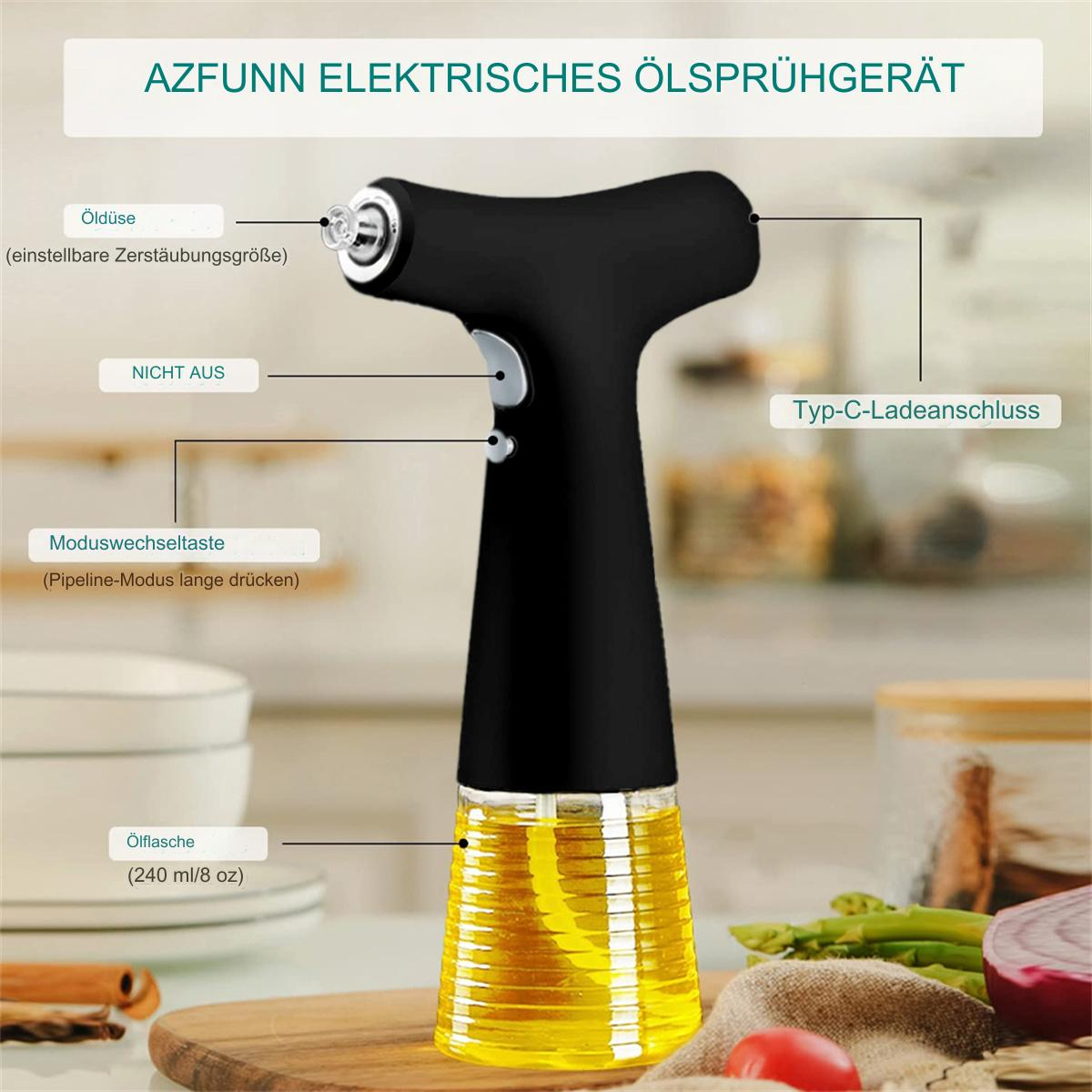 Ein schwarzes elektrisches Ölsprühgerät mit einem transparenten Ölbehälter, Etiketten auf Deutsch und einem Holzschneidebrett mit Gemüse im Hintergrund.