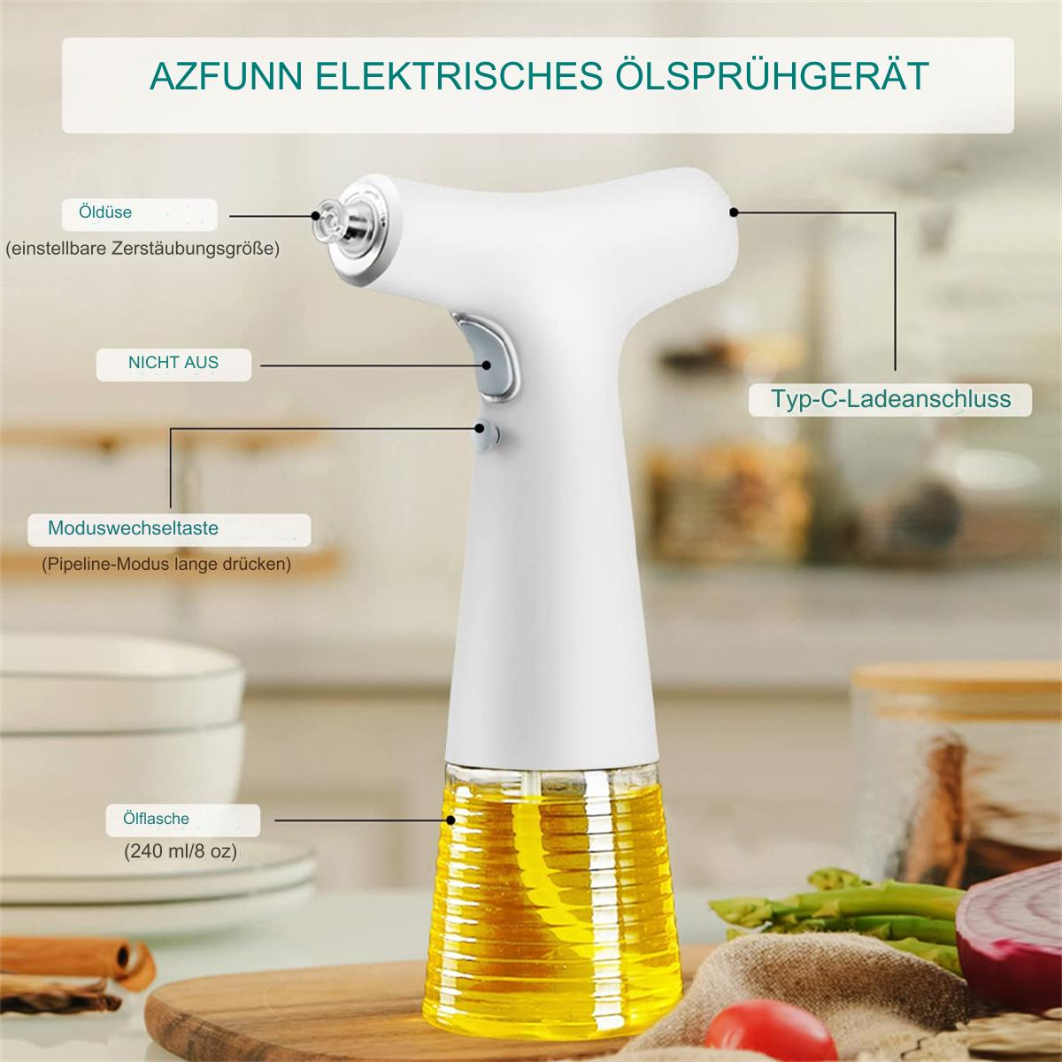 Ein weißes elektrisches Ölsprühgerät mit einem transparenten Ölbehälter, Etiketten auf Deutsch und einem Holzschneidebrett mit Gemüse im Hintergrund.