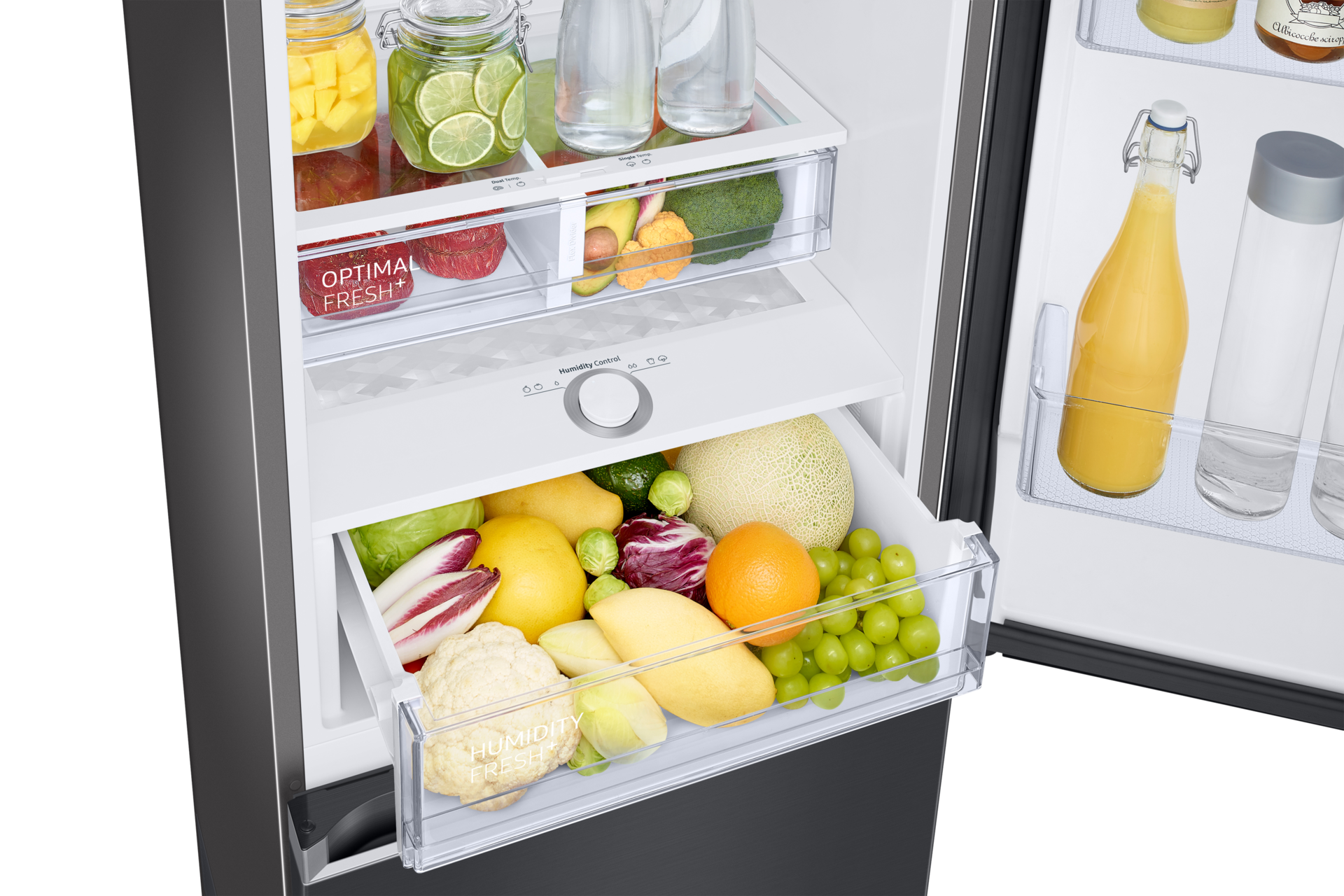 Offener Kühlschrank mit Obst und Gemüse. Gläser mit Obst oben. Schubladen mit Produkten wie Melone, Orangen, Blumenkohl.