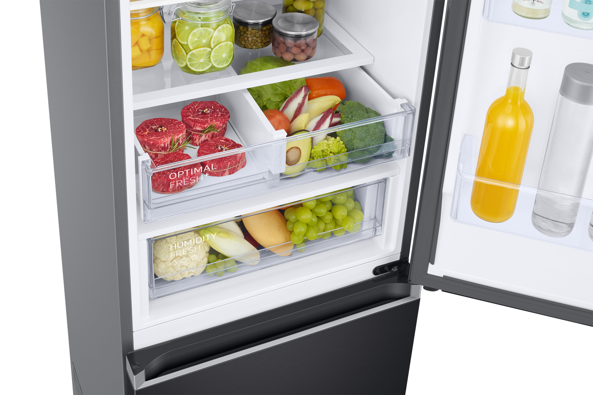 Offener Kühlschrank mit verschiedenen Lebensmitteln: Fleisch, Obst, Gemüse und Getränke. Artikel werden in Schubladen und Regalen aufbewahrt.