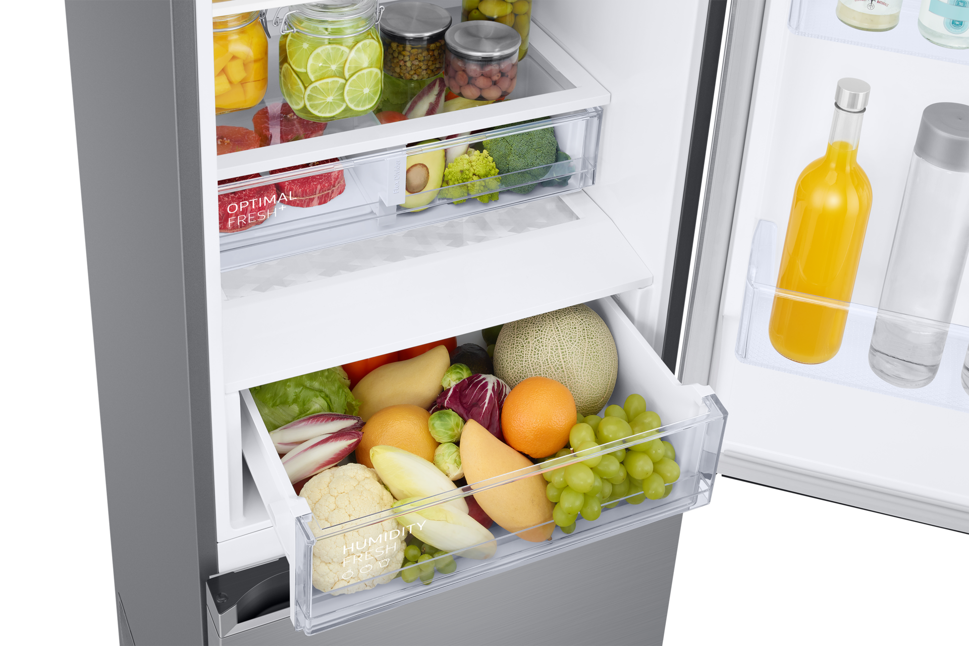 Offener Kühlschrank mit Obst und Gemüse. Gläser mit Lebensmitteln im obersten Regal. Untere Schublade mit Produkten wie Trauben und Blumenkohl.