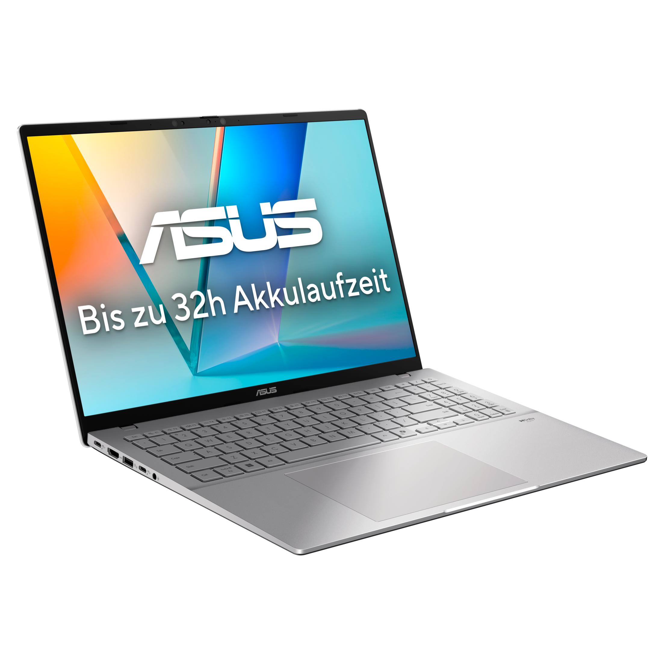 Srebrny laptop ASUS z ekranem wyświetlającym kolorową grafikę, tekst 'Bis zu 32h Akkulaufzeit'. Klawiatura widoczna.