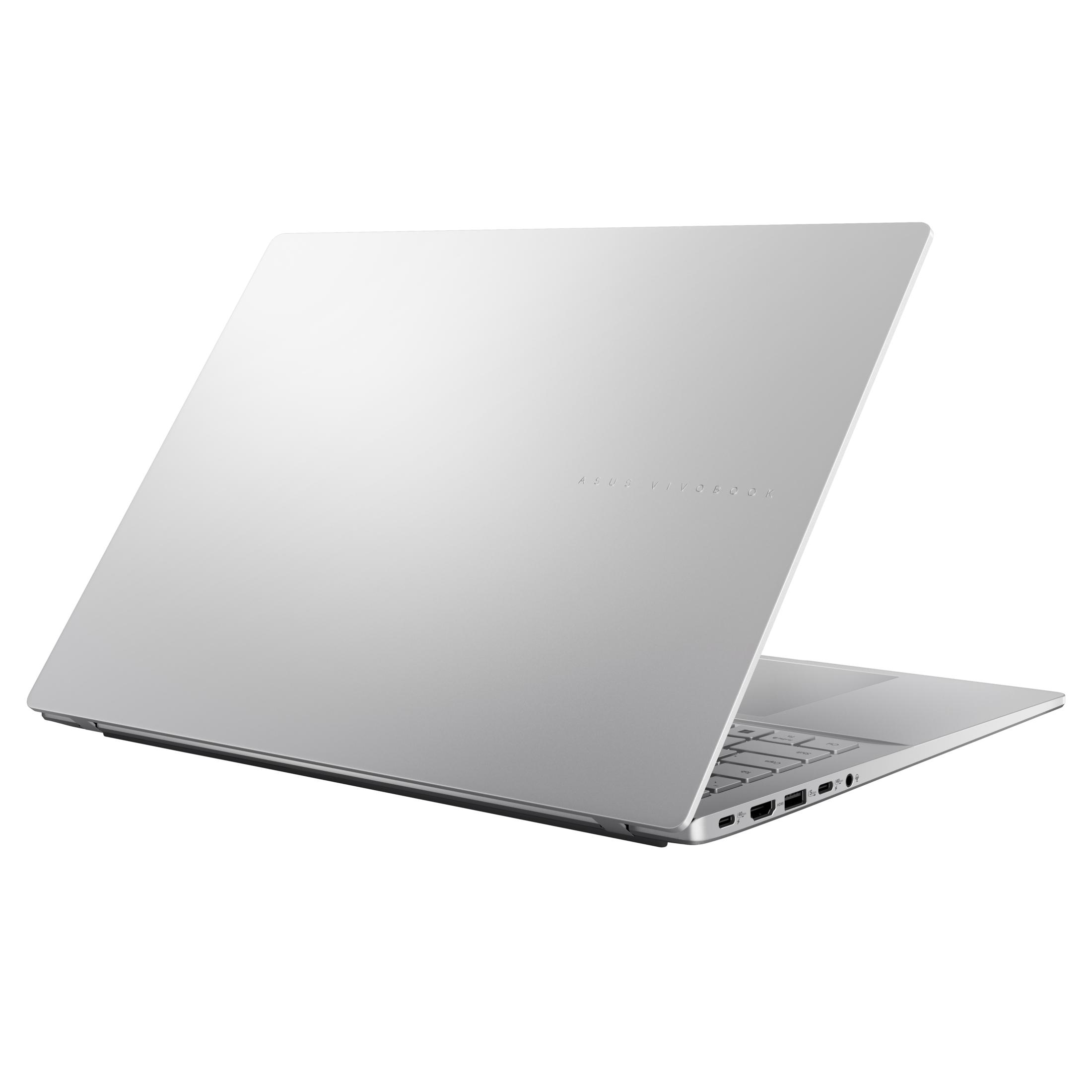 Srebrny laptop, częściowo otwarty, na białym tle. ASUS VIVOBOOK jest wydrukowany na pokrywie.