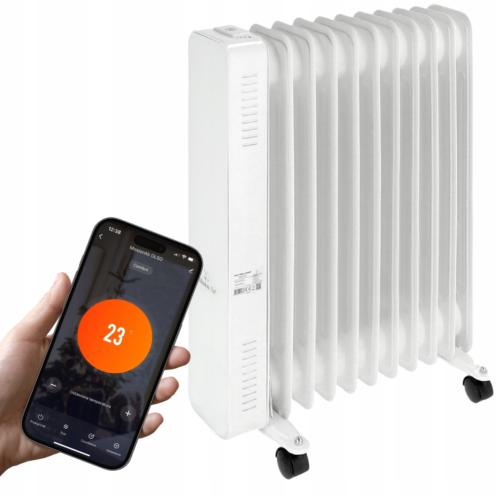 Biały grzejnik olejowy stoi obok dłoni trzymającej smartfon z temperaturą 23 stopnie.