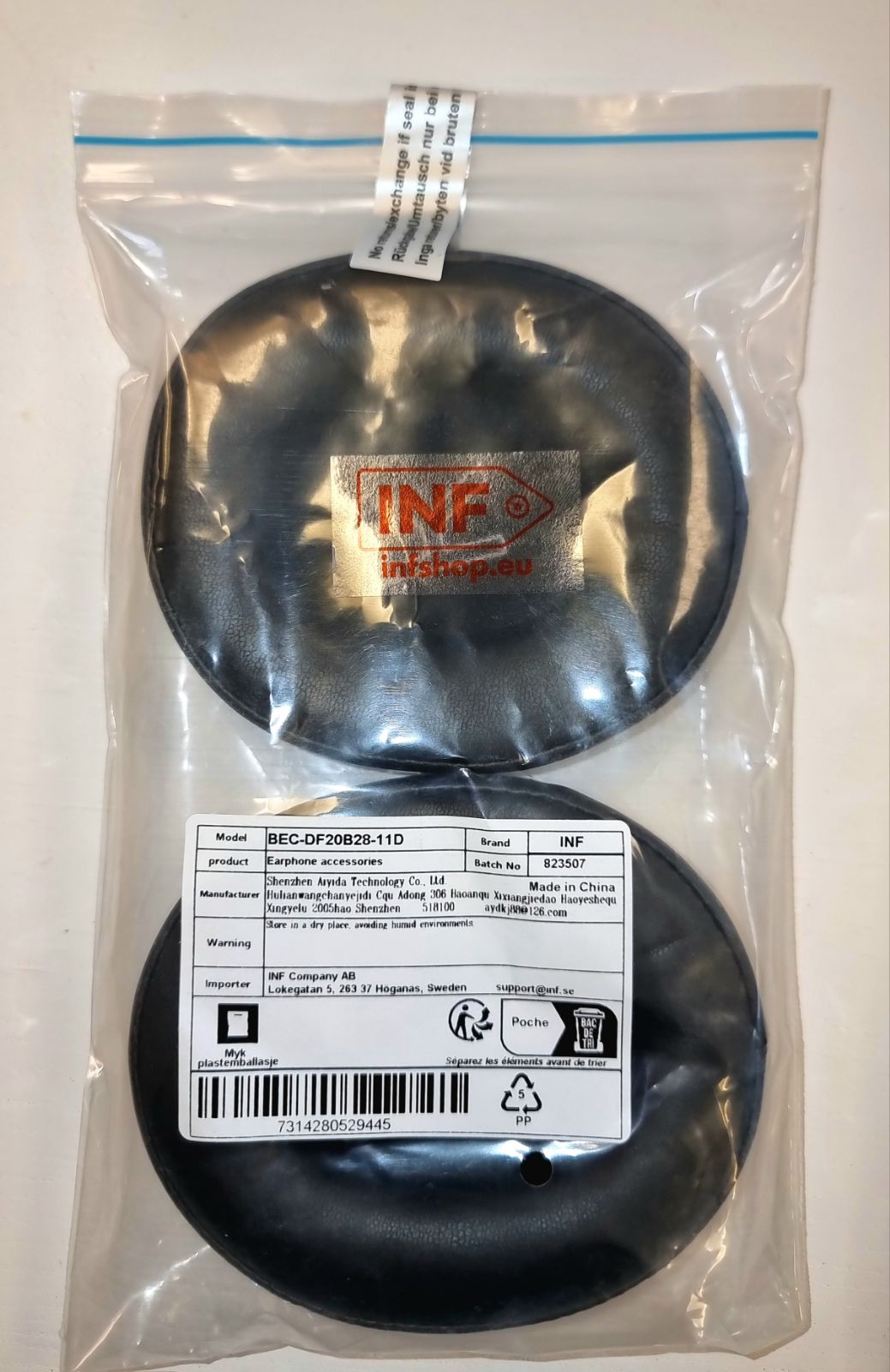 Twee zwarte oorkussens in een plastic zak met zichtbare productinformatie. De zak is verzegeld.