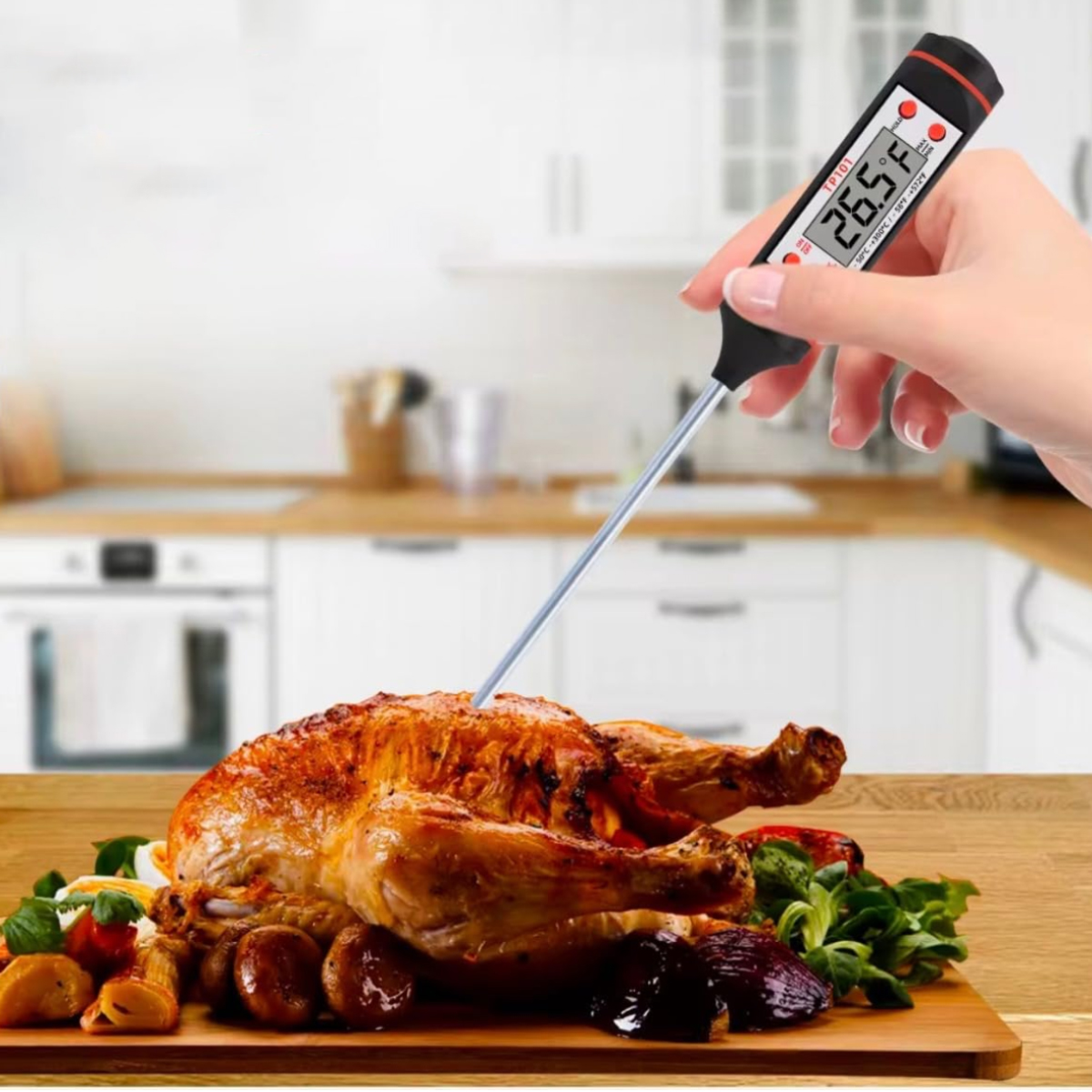 Eine Hand hält ein Thermometer und misst die Temperatur eines gebratenen Huhns auf einem Holzbrett mit Beilagen. Hintergrund Küche.