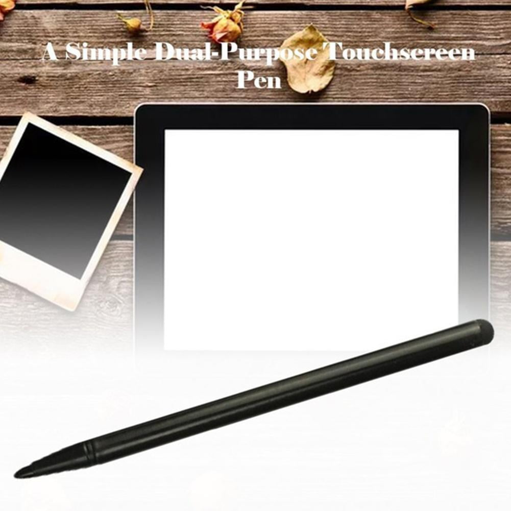 Ein schwarzer Stift mit einem Tablet und einem Polaroidfoto auf holzfarbenem Hintergrund. Einige getrocknete Blumen und ein Blatt sind platziert.