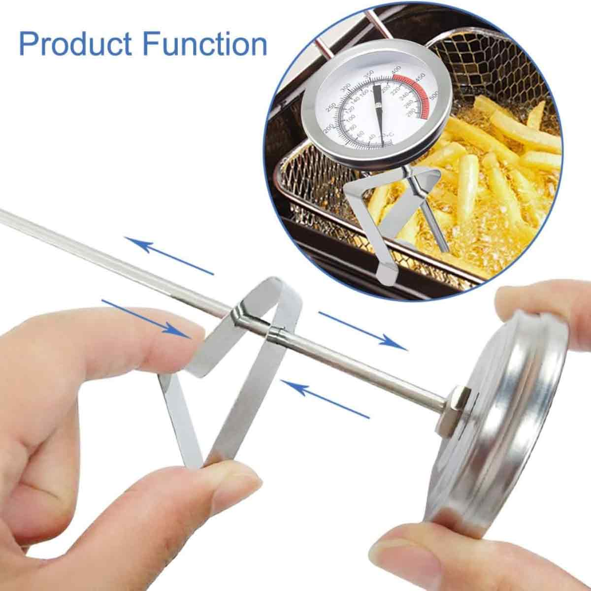 Eine Hand hält ein Thermometer, das Zifferblatt zeigt die Temperatur an. Das Thermometer befindet sich in einem Korb mit Pommes Frites in heißem Öl.