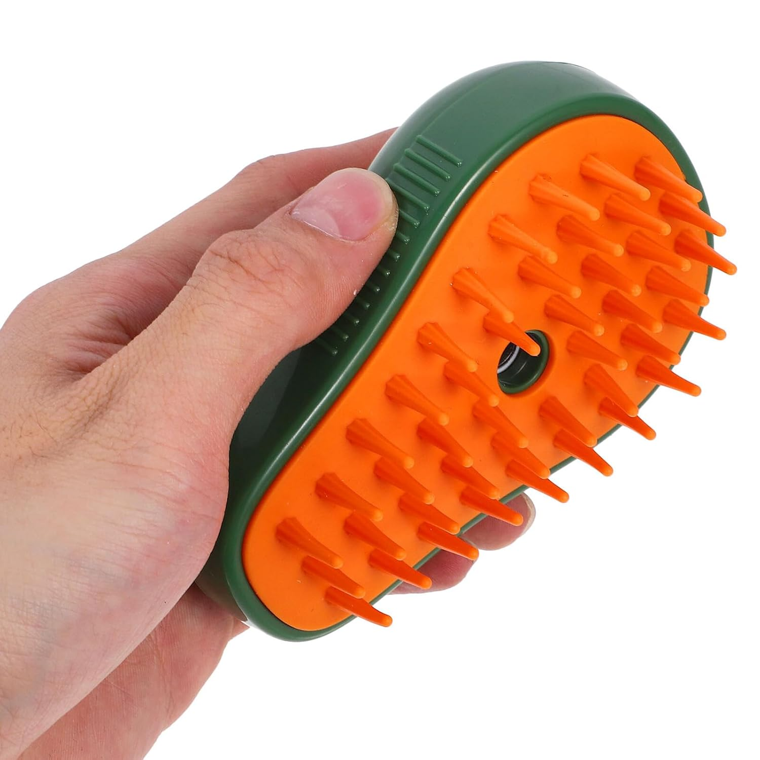 Eine Hand, die einen grün-orangenen Kopfhautmassager hält. Der Massager hat orangefarbene Borsten. Der Hintergrund ist weiß.
