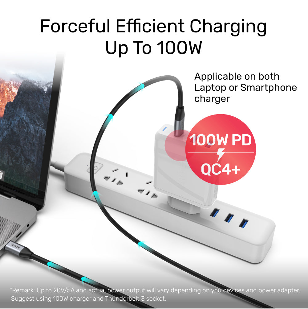 Een witte stekkerdoos met oplader en kabel. Tekst luidt 'Forceful Efficient Charging Up To 100W'. Een laptop is gedeeltelijk zichtbaar.