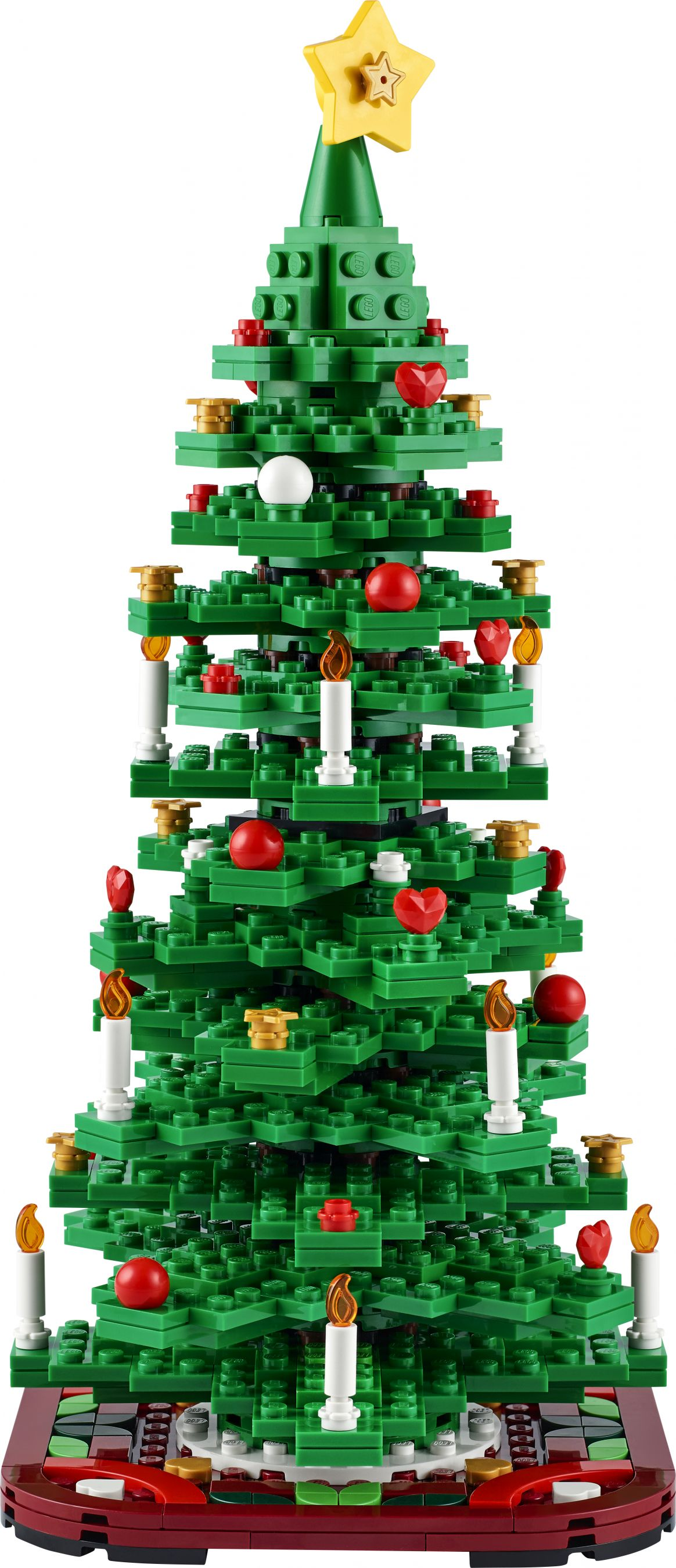 Ein LEGO-Weihnachtsbaum aus grünen Steinen mit roten Kugeln, Kerzen und einem gelben Stern oben. Er steht auf einer roten Basis.