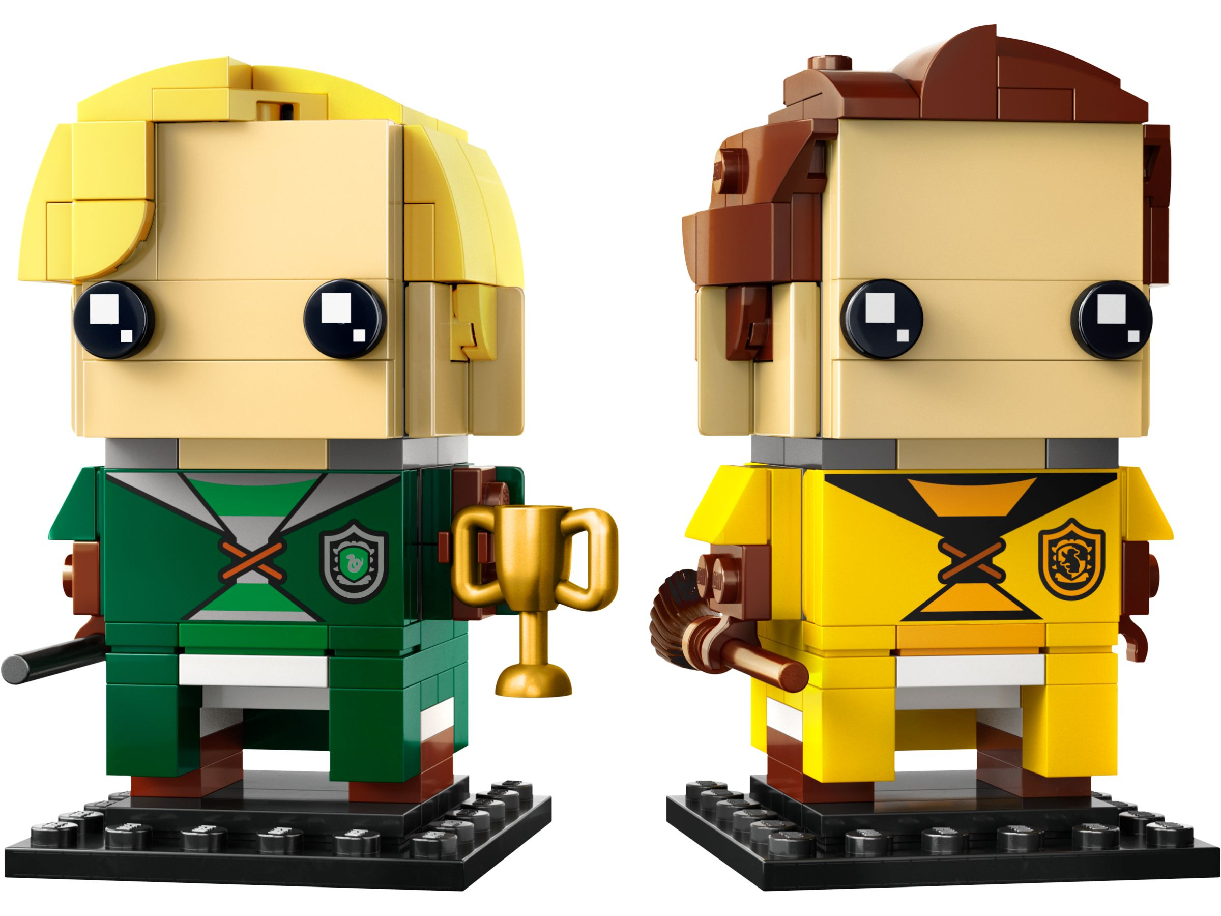 Zwei Lego-Figuren, blond und braunhaarig, grüne und gelbe Uniformen, schwarze Augen, halten eine Trophäe und einen Besen.