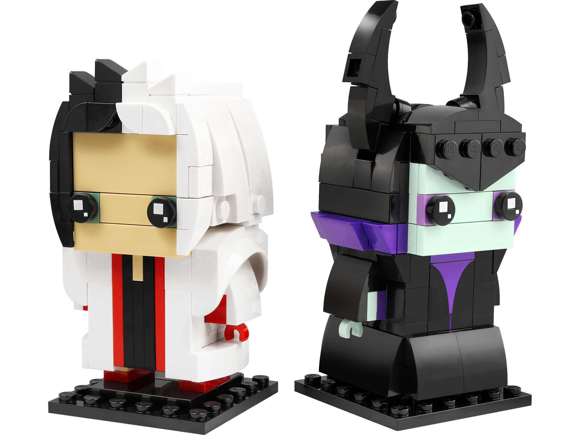 Zwei Lego-ähnliche Figuren: eine weiße mit schwarzen Akzenten, die andere schwarz mit lila und grünen Akzenten. Beide stehen auf schwarzen Sockeln.