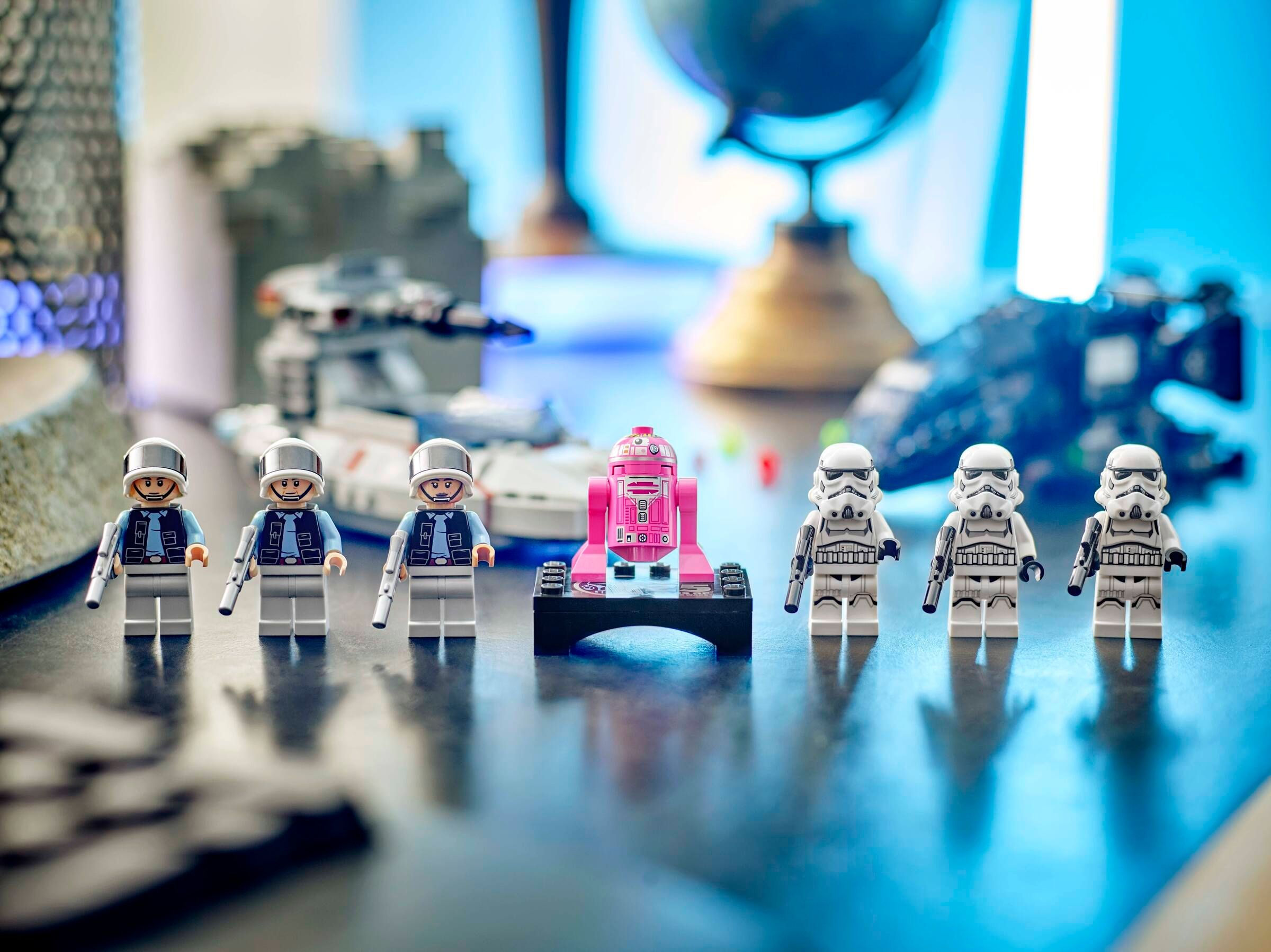 Figurki Lego Star Wars: piloci rebelianccy, R2-D2 i szturmowcy. Tło: globus i statki kosmiczne.
