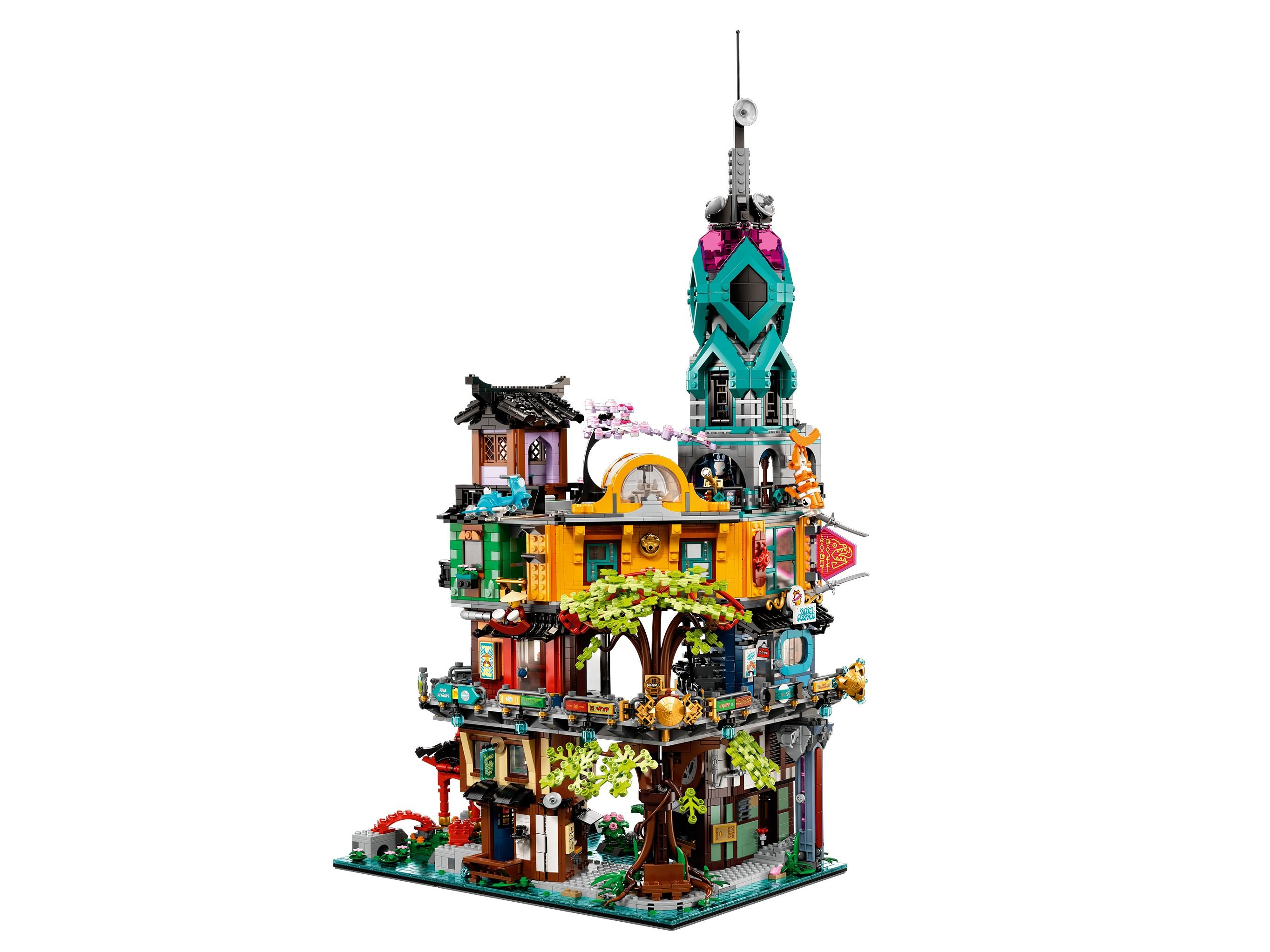 Ein farbenfrohes Lego-Gebäude mit mehreren Etagen, einem hohen Turm und Details wie Bäumen und Schildern.