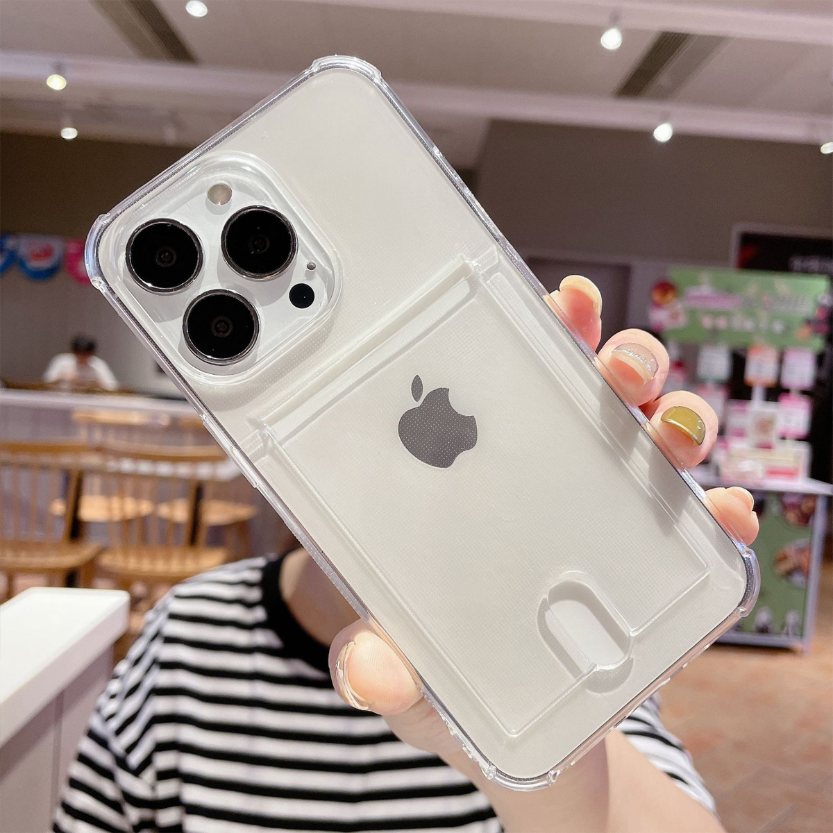 Eine Hand hält eine transparente Handyhülle mit einem iPhone darin. Die Hülle hat einen Kartenhalter, und das Apple-Logo ist sichtbar.