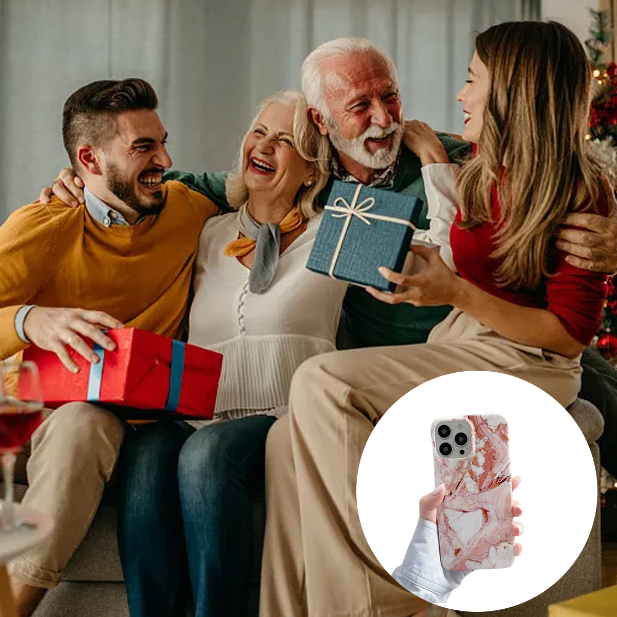 Eine Familie tauscht Geschenke auf einem Sofa aus. Alle lächeln. Im Vordergrund wird eine Handyhülle mit Marmordesign gehalten.