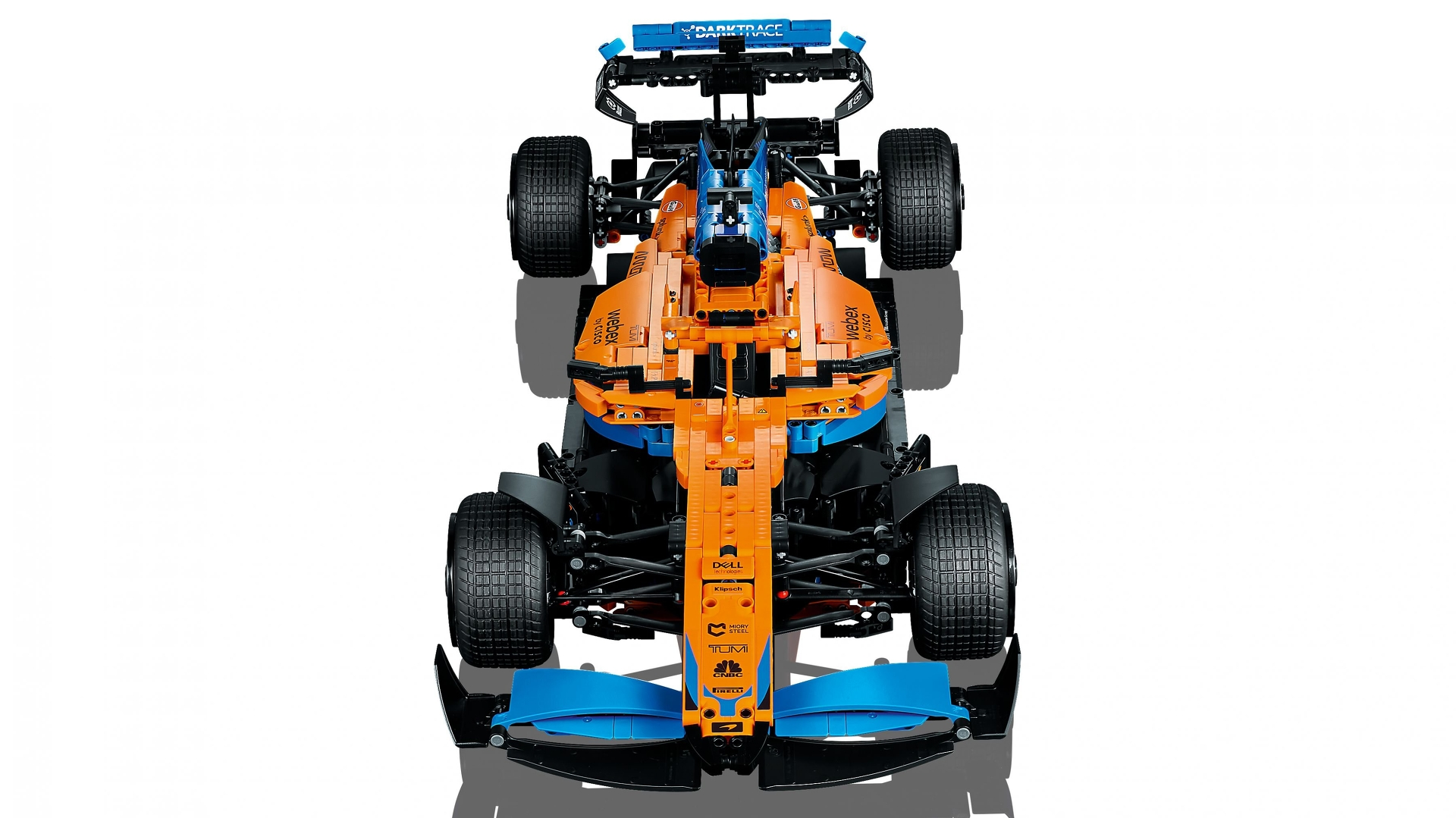 Draufsicht auf ein orange-blaues Rennwagenmodell. Es hat große Reifen, Sponsorenlogos und einen dunklen Schatten.