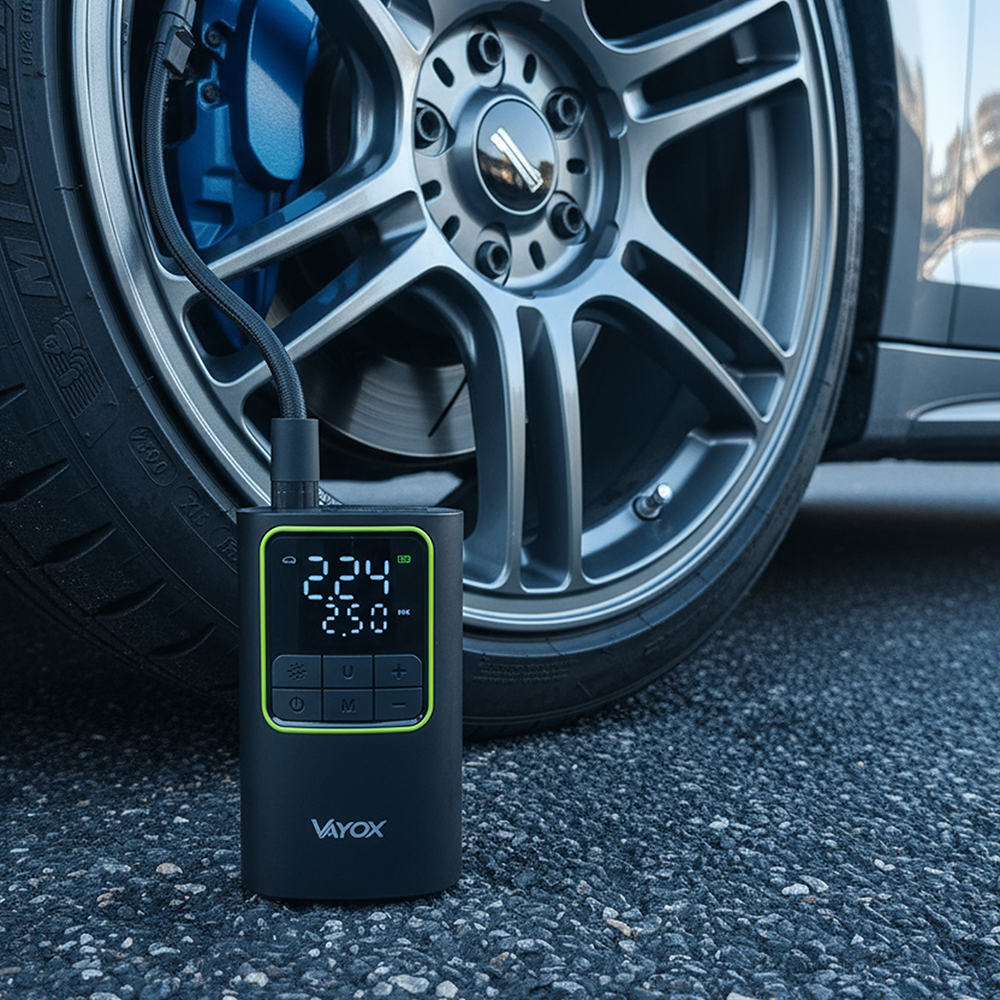 Pompka do opon jest podłączona do opony samochodowej. Pompka pokazuje odczyt ciśnienia. Samochód stoi na asfalcie.