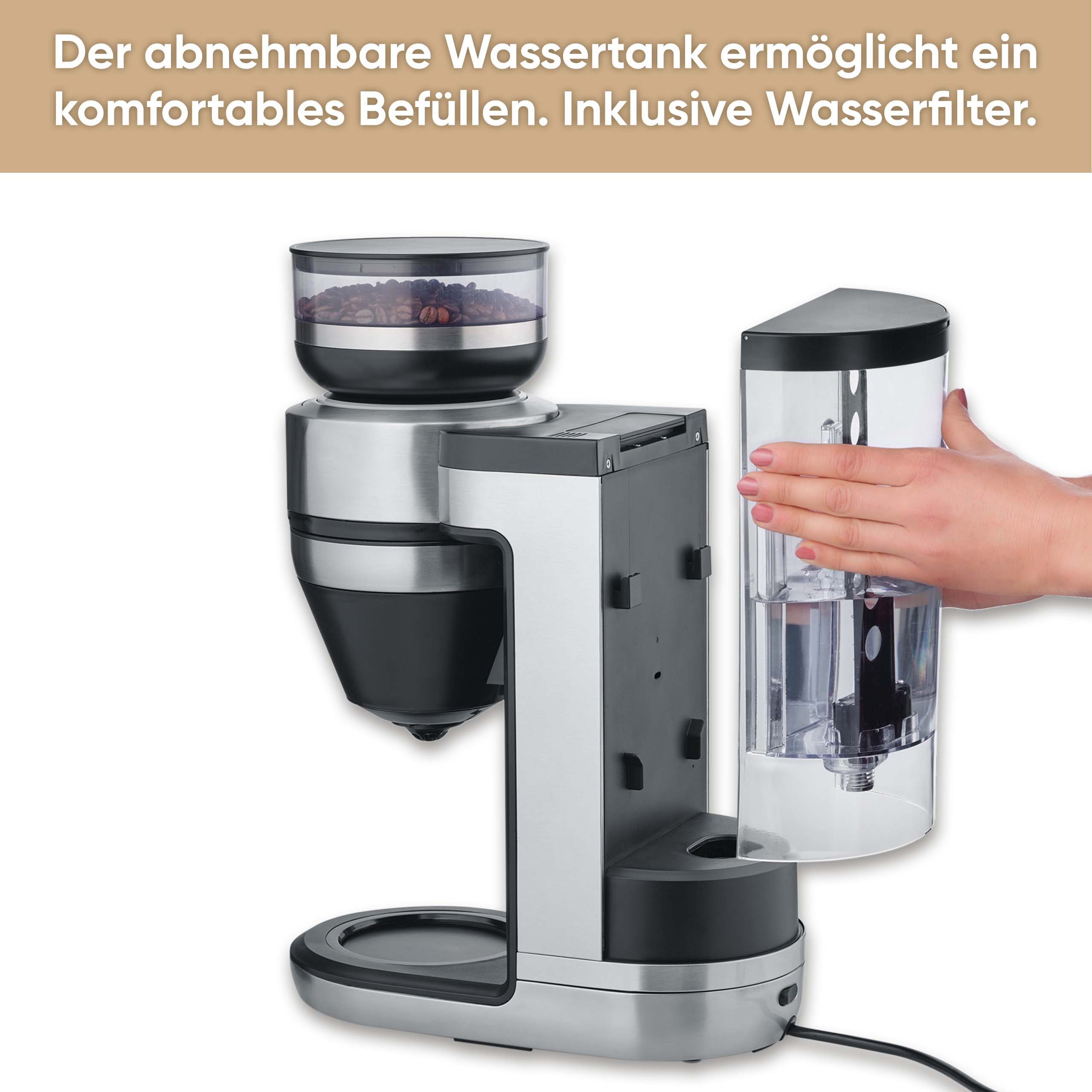 A coffee machine with a bean container, water tank, and a hand holding the water tank. The machine is silver and black.