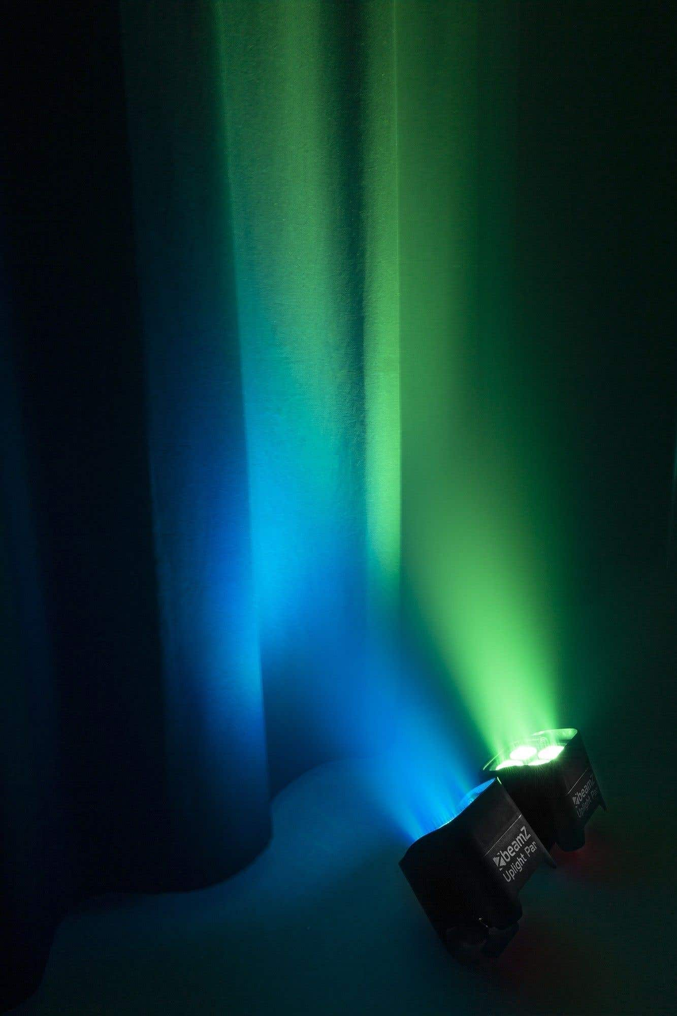 Dos focos negros proyectan luz azul y verde sobre un fondo oscuro. Las luces están etiquetadas como Beamz Uplight Par.