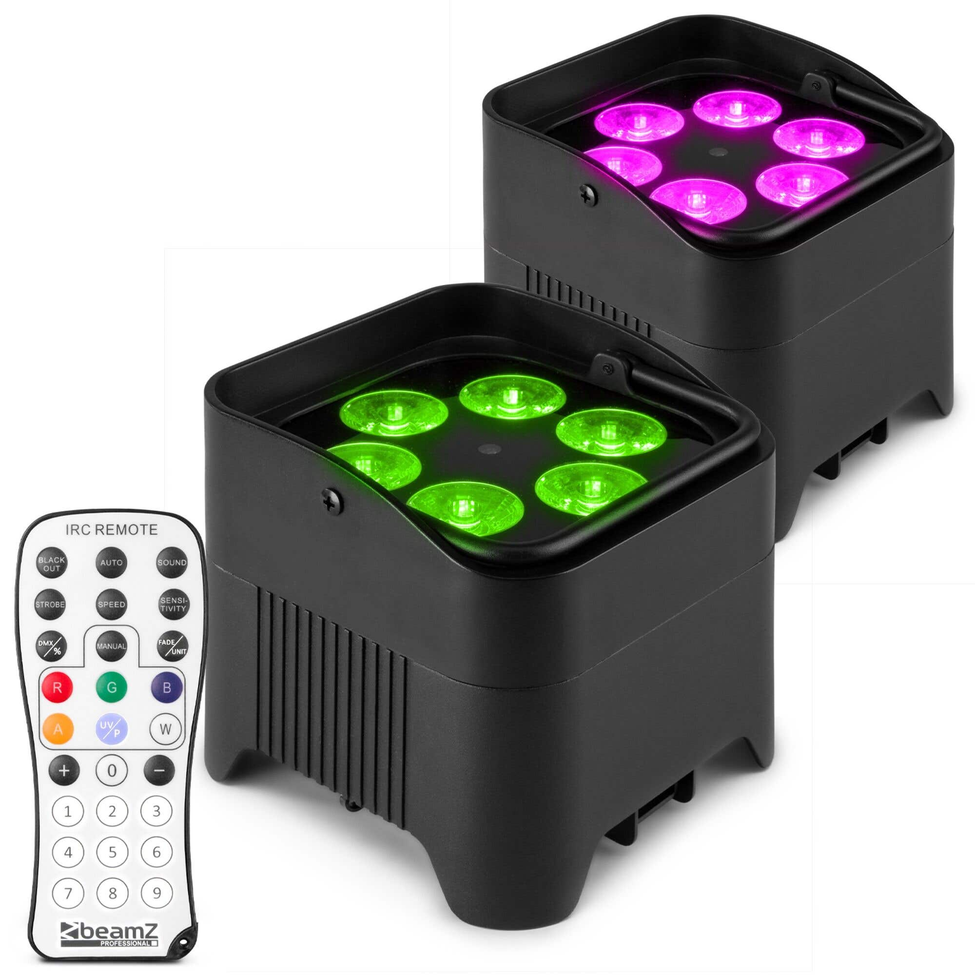 Dos luces de escenario negras con luces verdes y moradas. Un mando a distancia está a la izquierda.