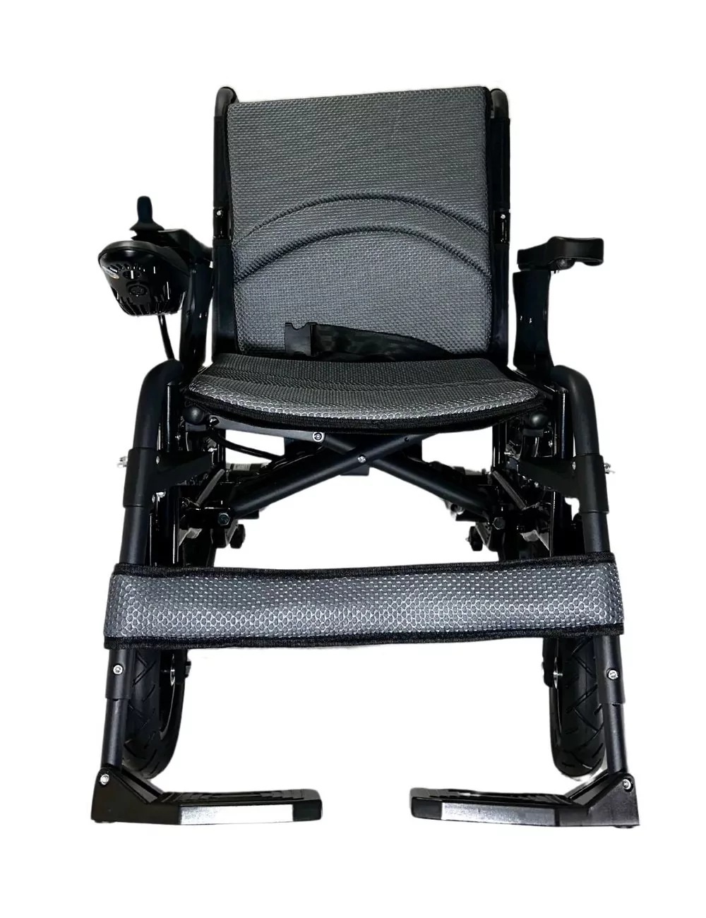Una silla de ruedas eléctrica negra y gris. Incluye joystick, cinturón de seguridad, reposapiés y neumáticos macizos sobre fondo blanco.