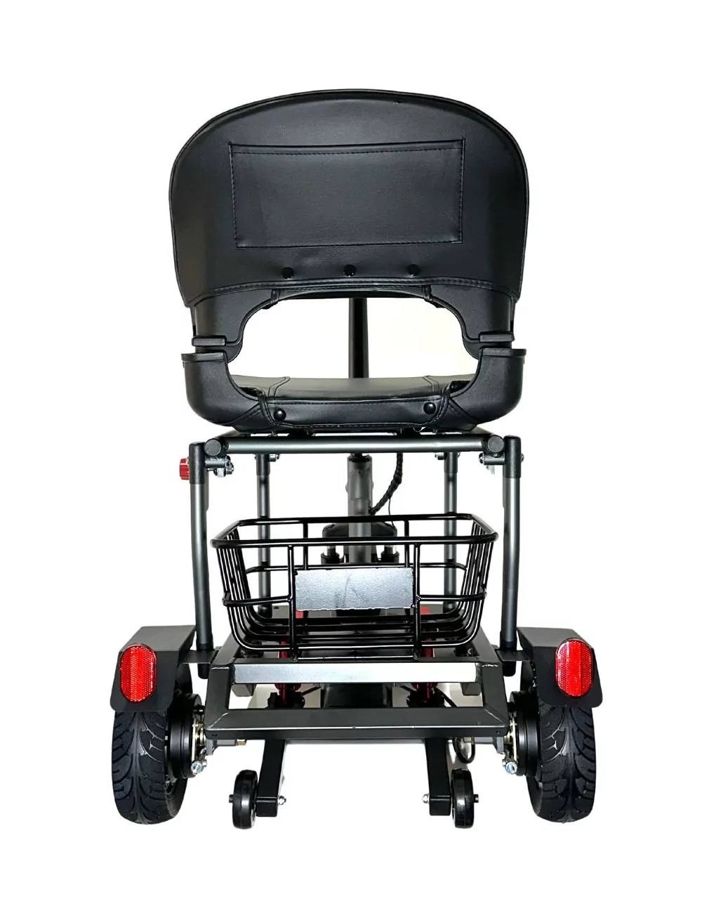Vista trasera de un scooter de movilidad negro. Tiene asiento, cesta y ruedas. Se ven reflectores rojos. El fondo es blanco.