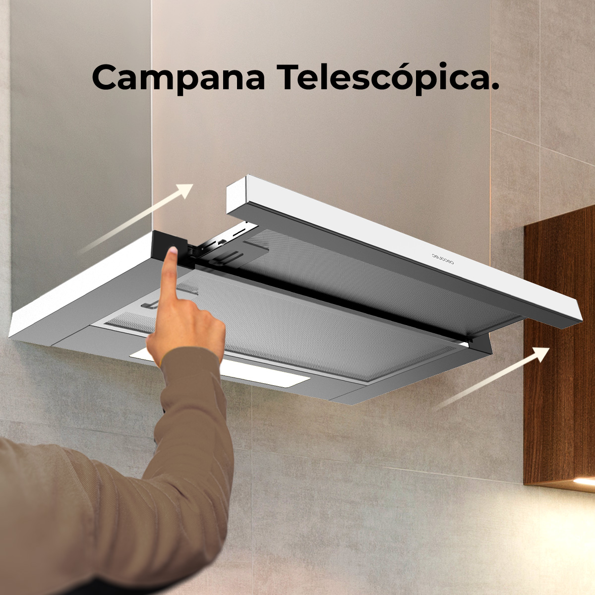 Una mano señala una campana extractora retráctil. La campana es plateada y blanca, con un filtro de malla abierto.