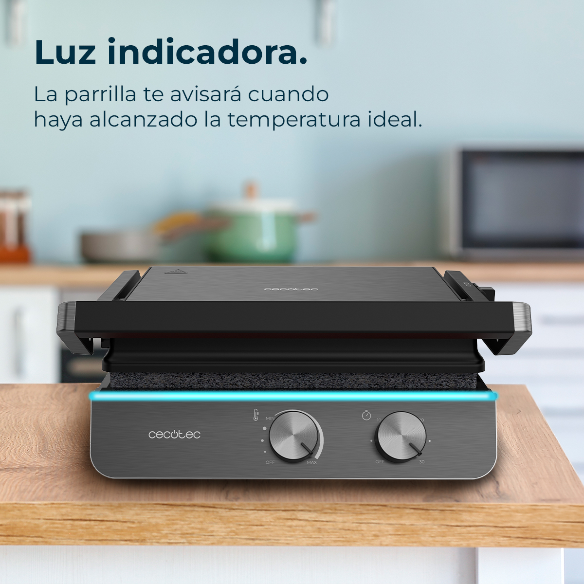 Een zwarte grill staat op een houten oppervlak. Knoppen en indicatielampjes zijn zichtbaar. Keukenachtergrond met magnetron en potten.