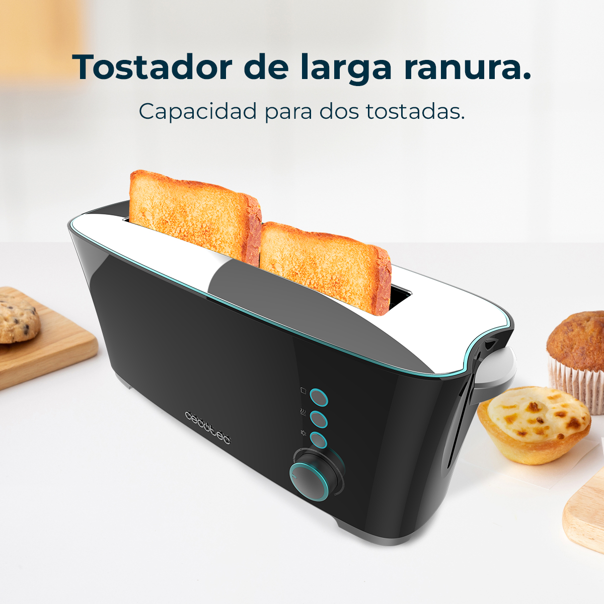 Un tostapane nero con due fette di pane tostato. Ci sono biscotti, un muffin e un pasticcino su una superficie bianca.