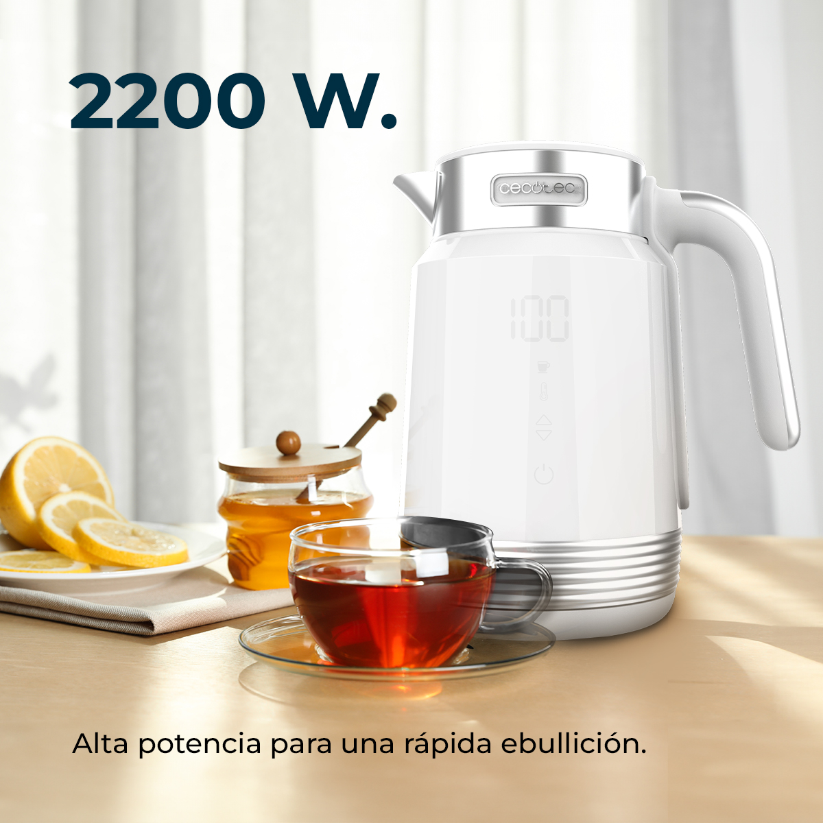 Un bollitore elettrico bianco con display digitale, una tazza di tè, fette di limone e miele su un tavolo. Il testo dice '2200 W'.
