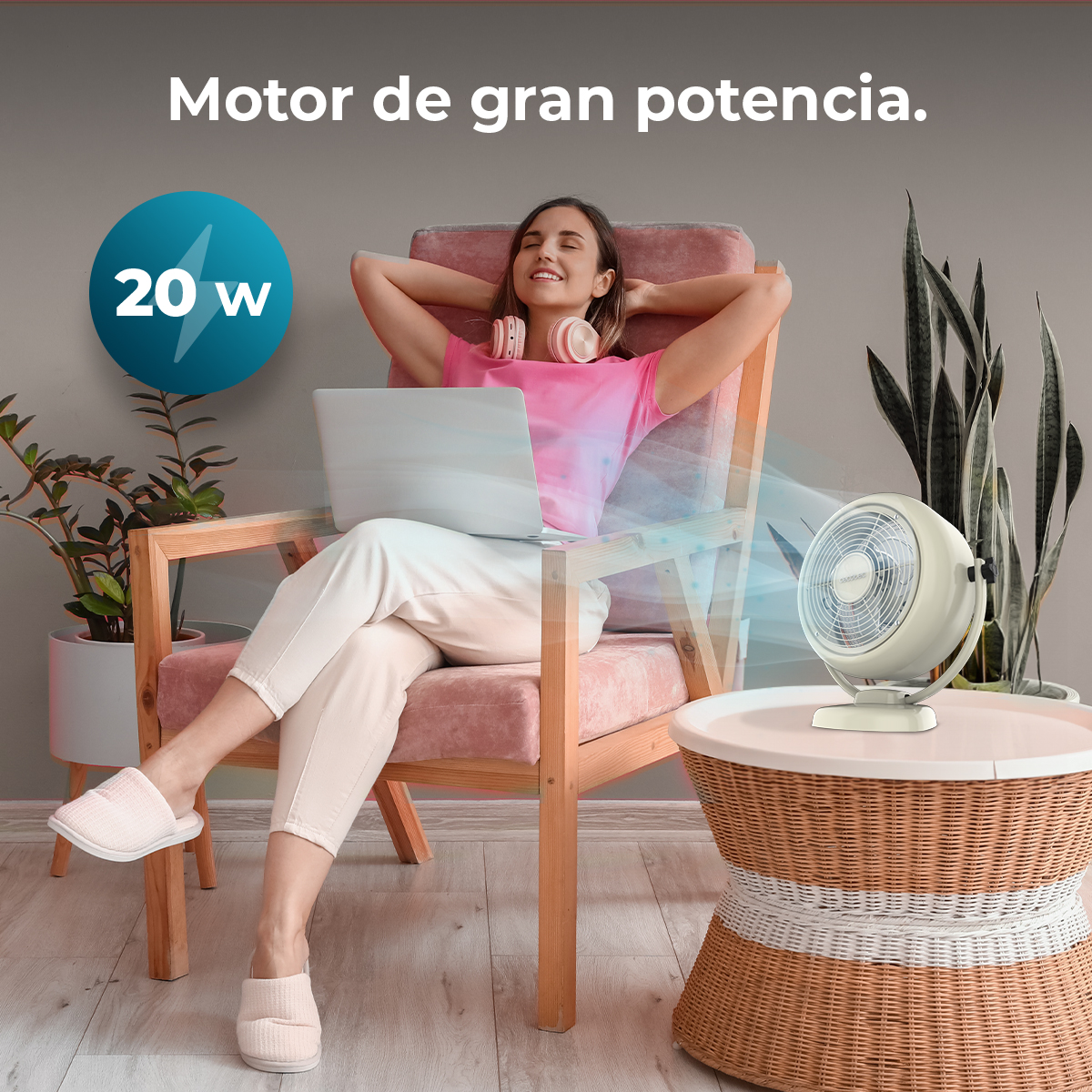 Donna che si rilassa con laptop, ventilatore e piante. Testo: Motor de gran potencia e 20w.